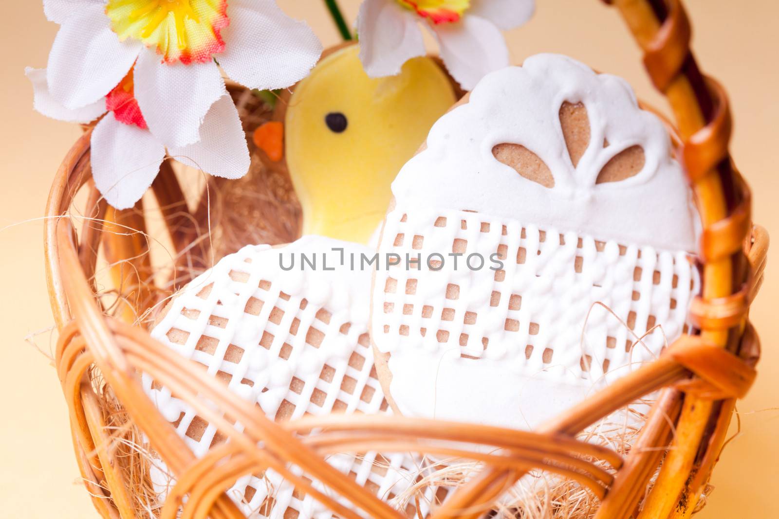 Easter cookies in basket over yellow background. Easter decor