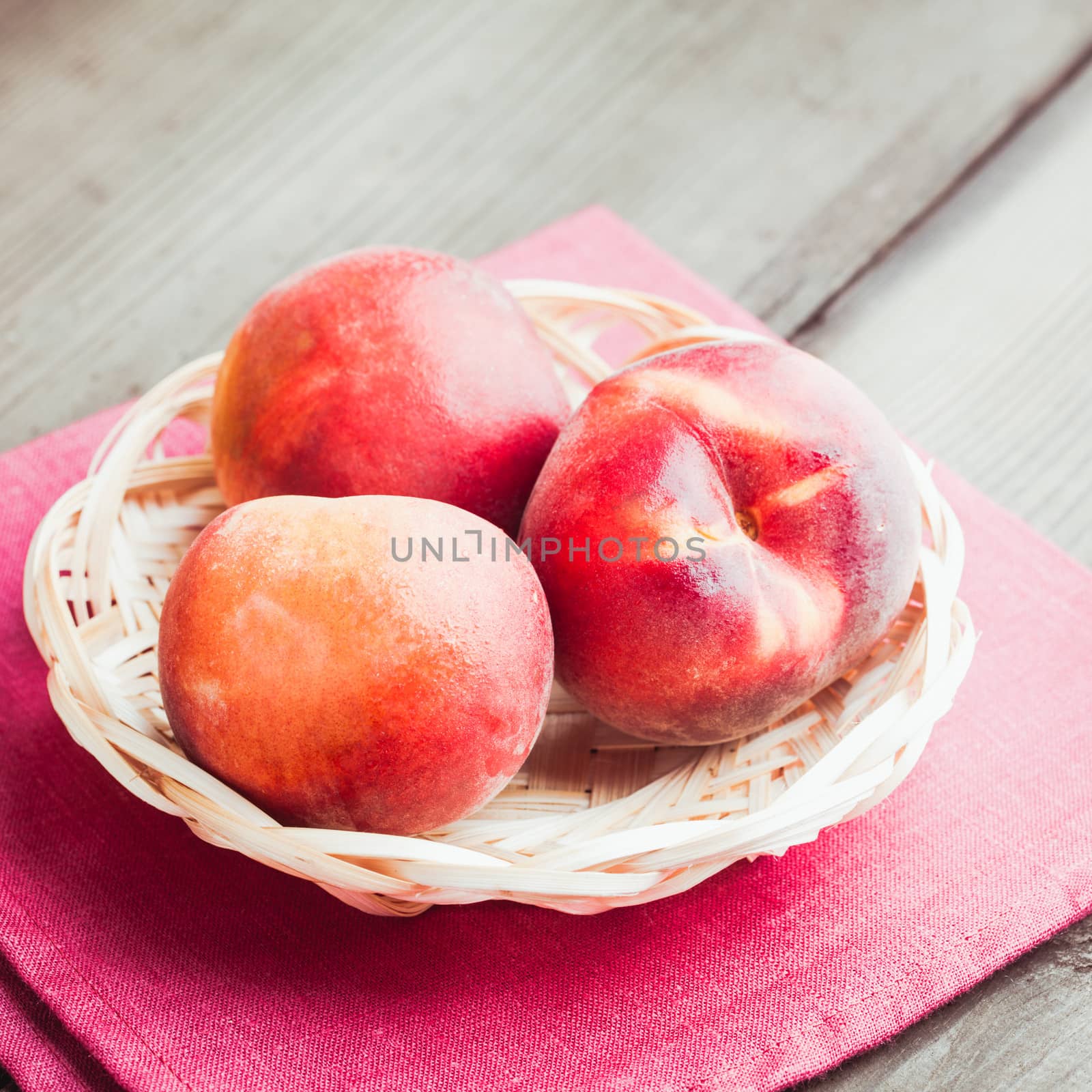 Peaches in the wooven bowl on the table