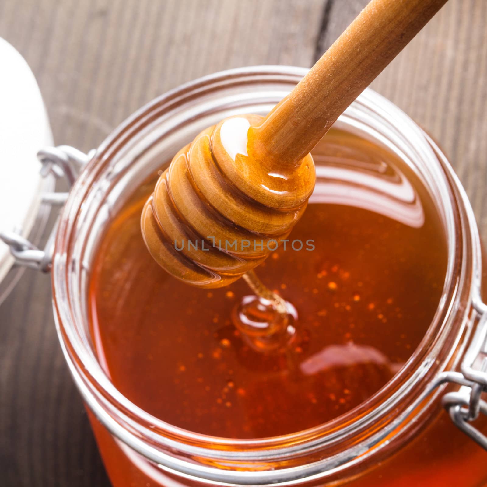 Honey drip in jar on the table