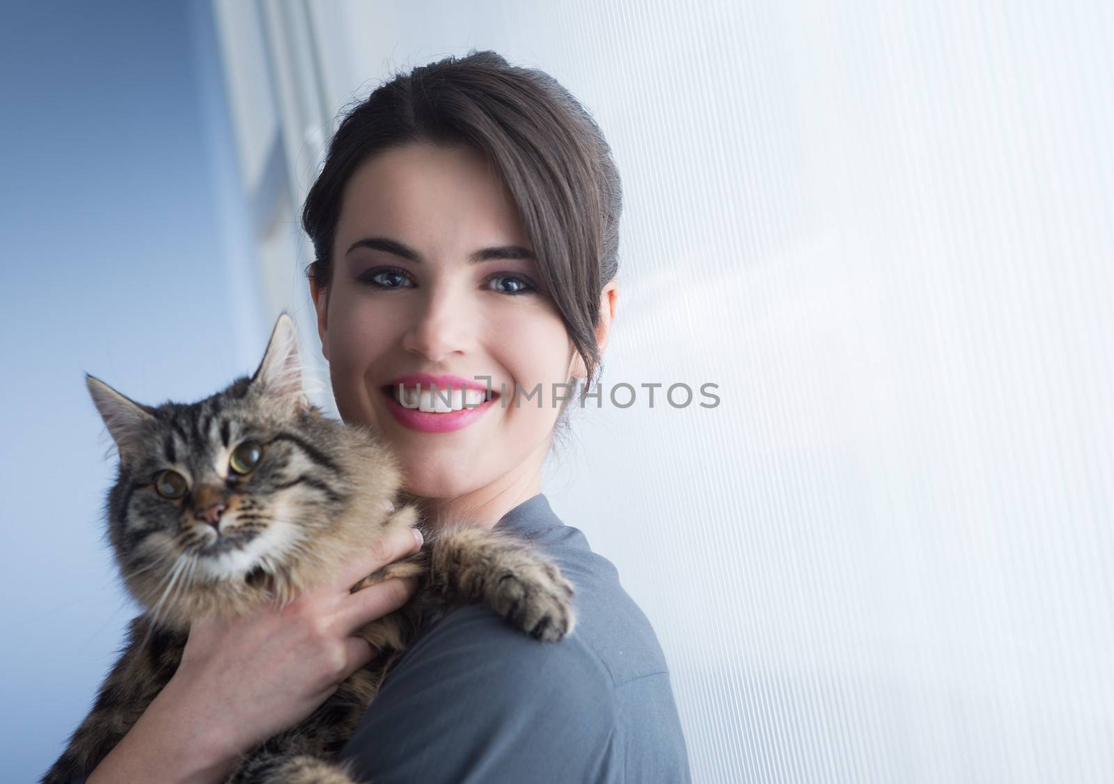 Beautiful woman smiling and holding a cute long hair cat.