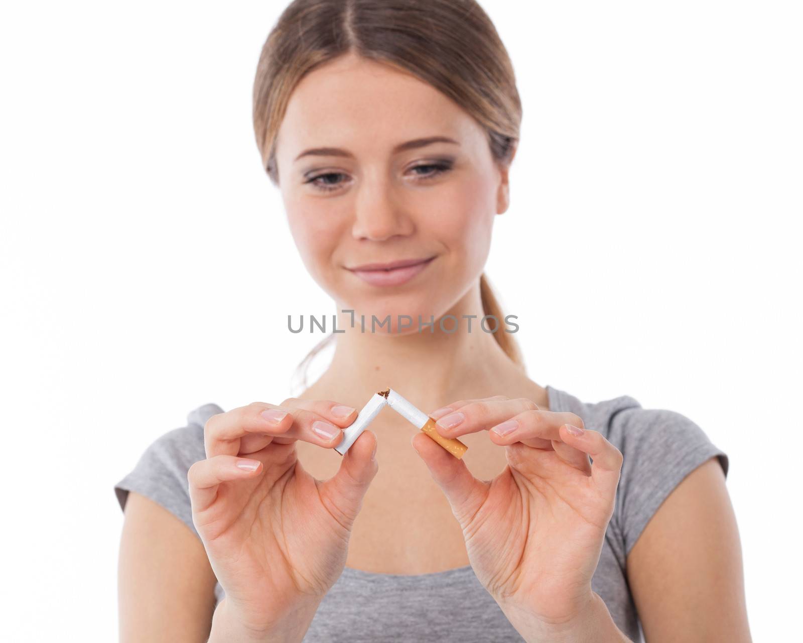 Young beautiful woman with broken cigarette, stop smoking concept