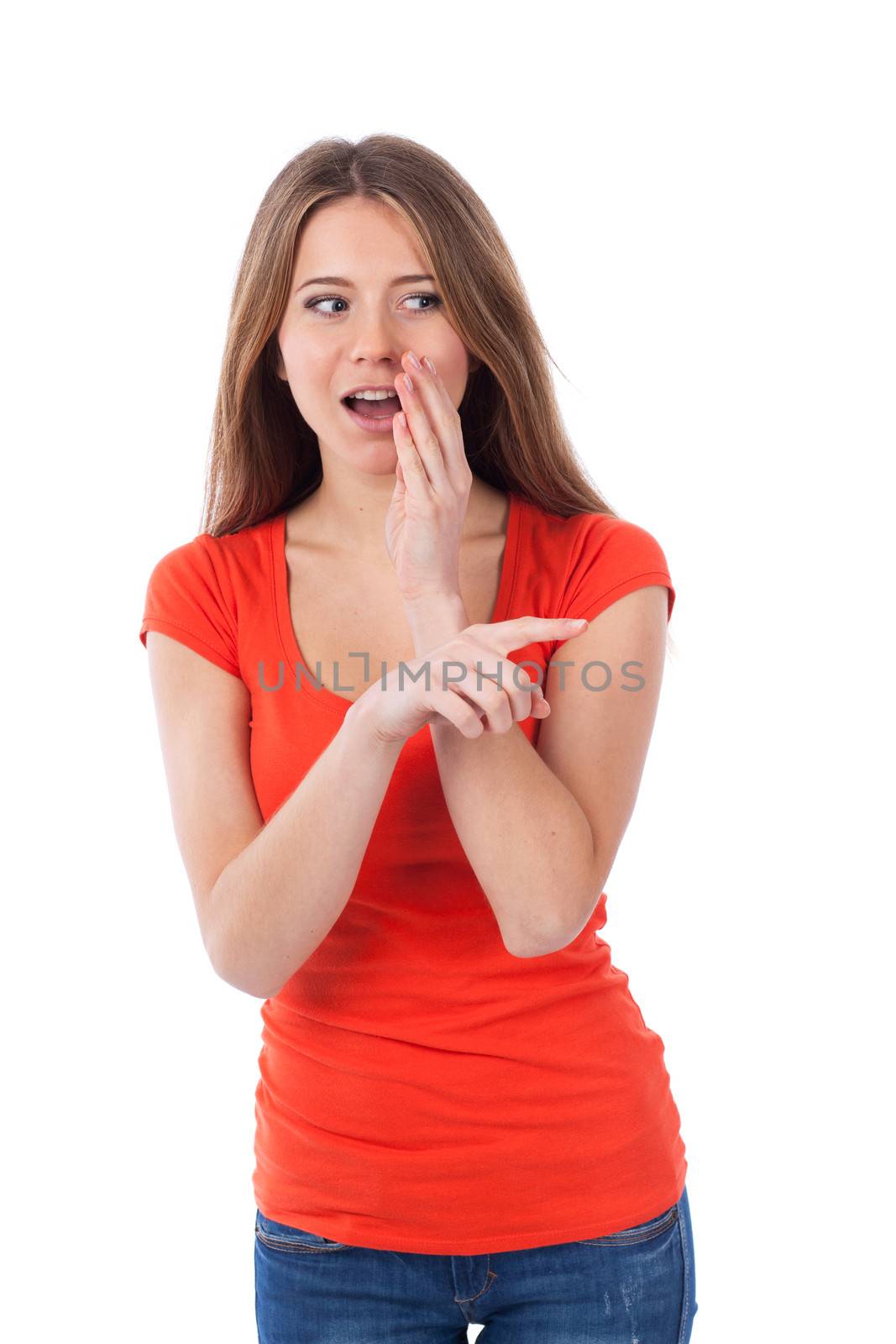 Young woman whispering and showing something with her finger, isolated on white