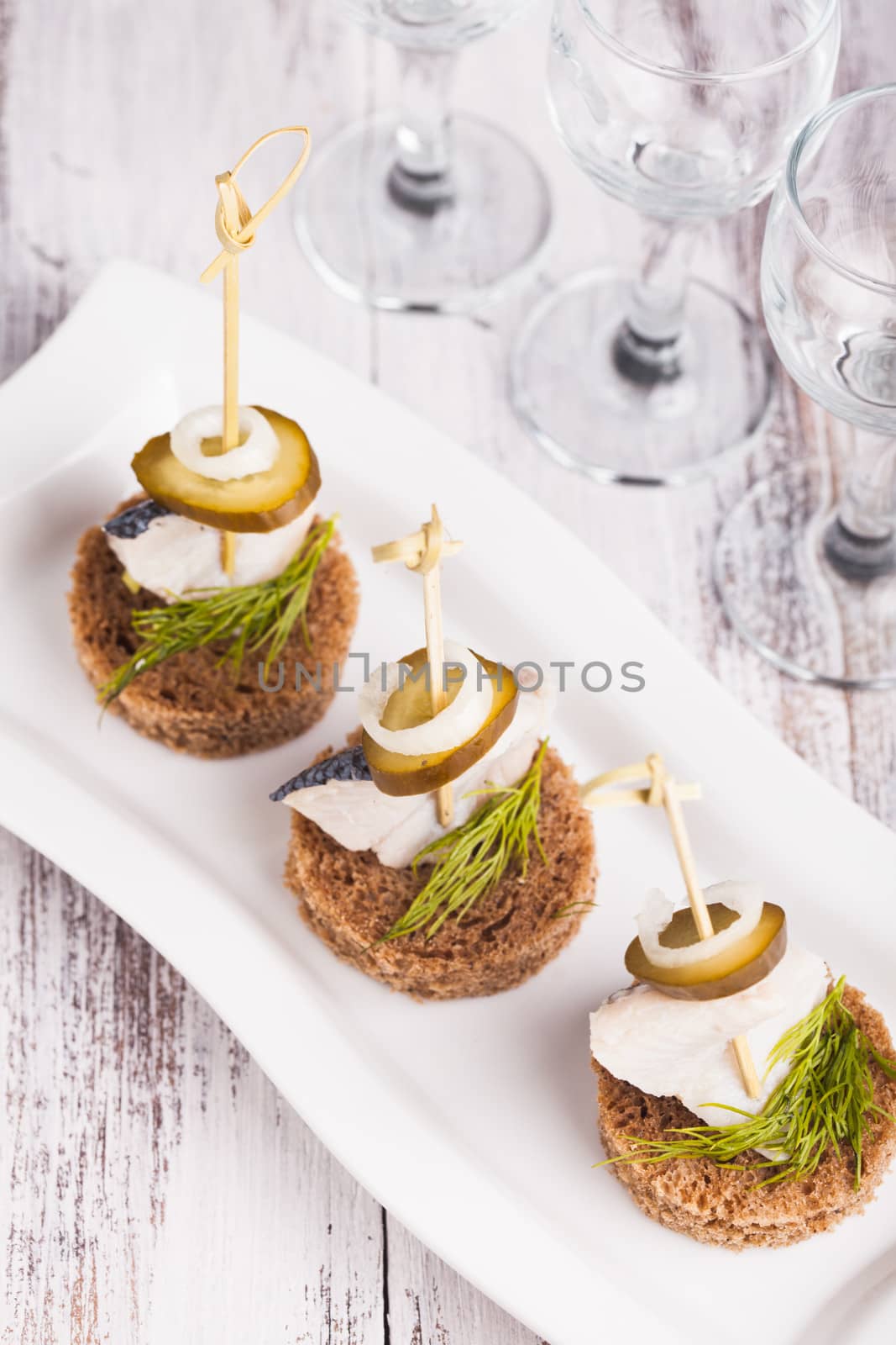 Herring canape with onion, pickled cucumber and dill