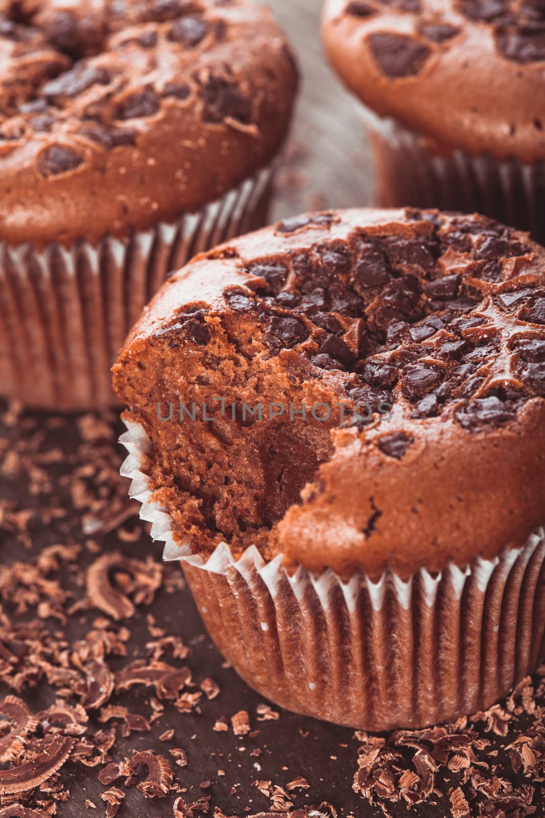 Chocolate muffins with chocolate chips on the wood background closeup