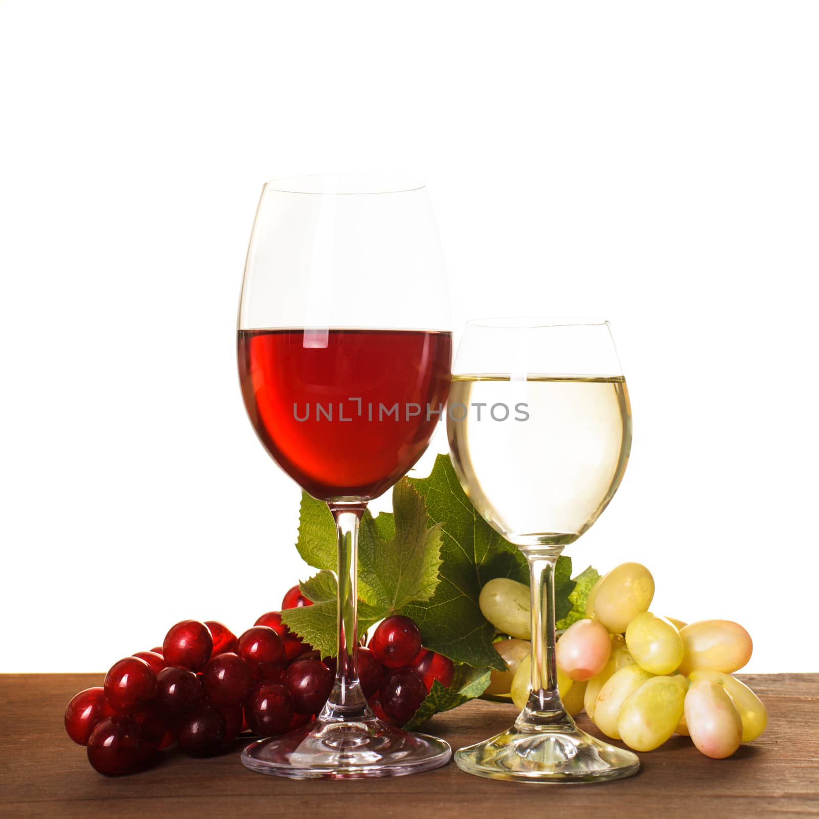 Red and white wine in glass over wooden table