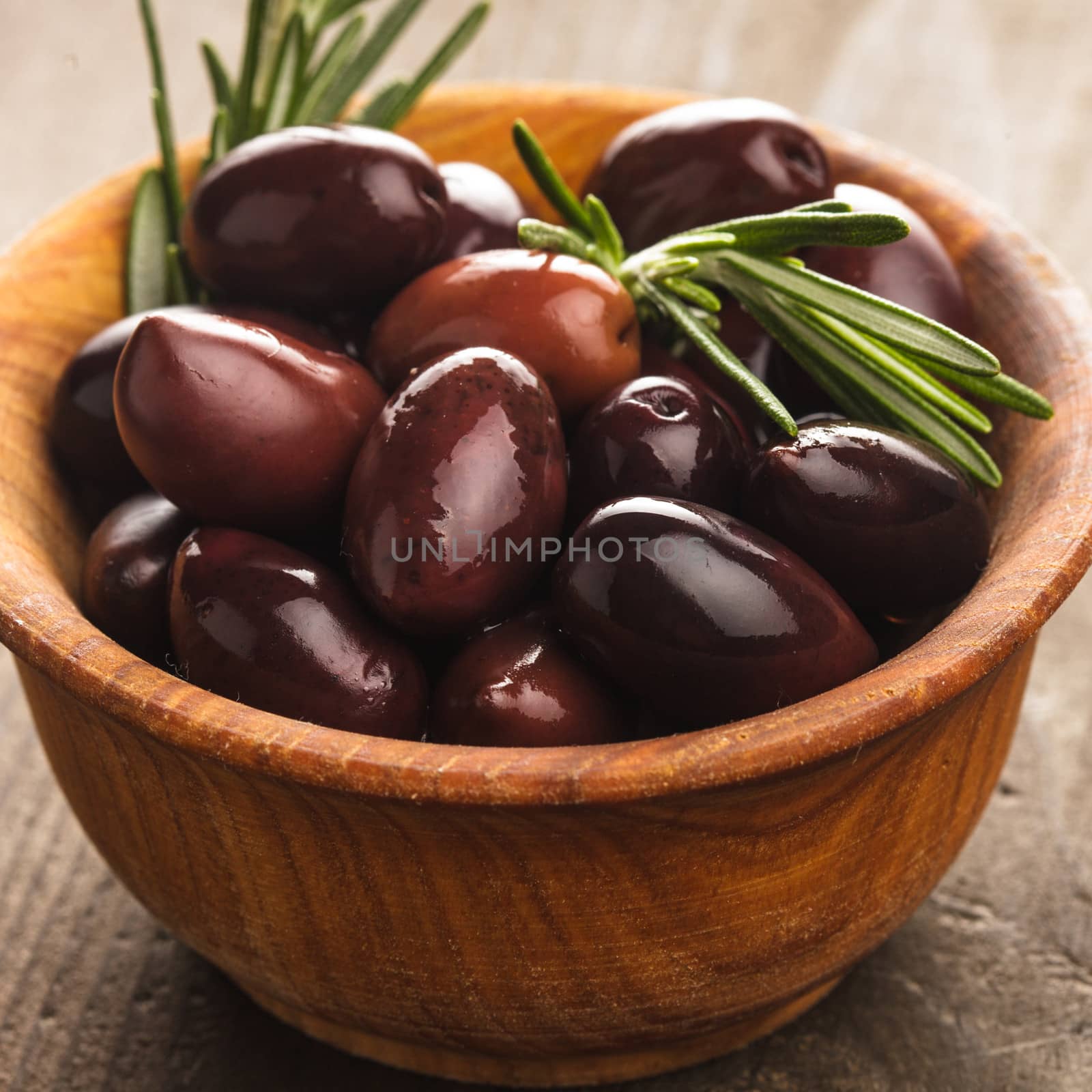 Olives calamata in wooden bowl on the table