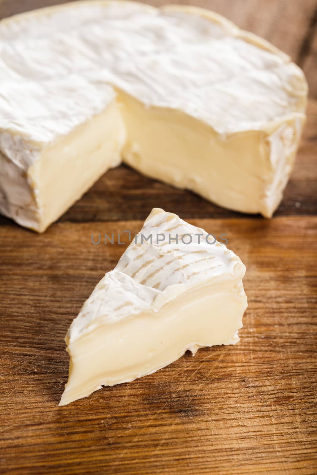 camembert cheese slice over the wooden board