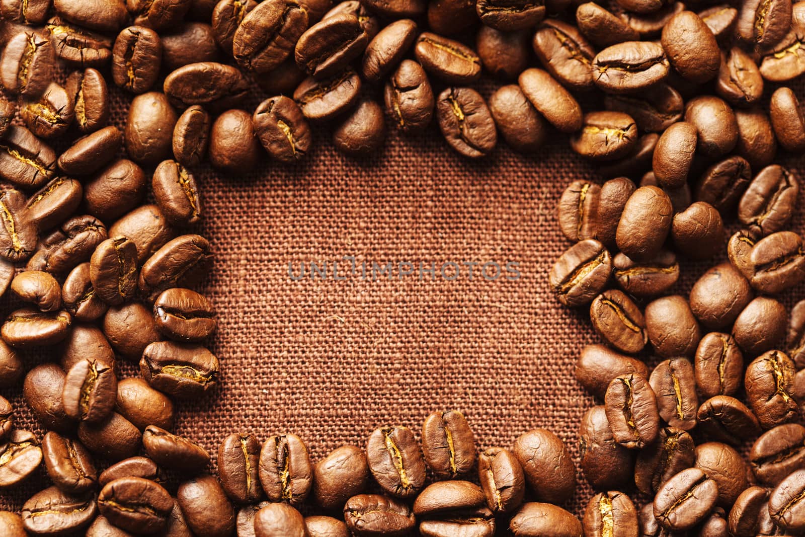 Spilled coffee beans frame over linen textile