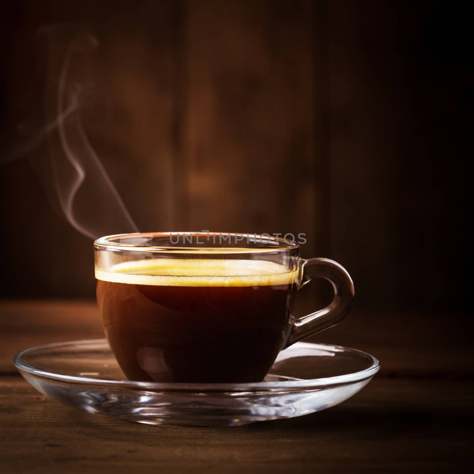 Cup of coffee with 
fume on the wooden background