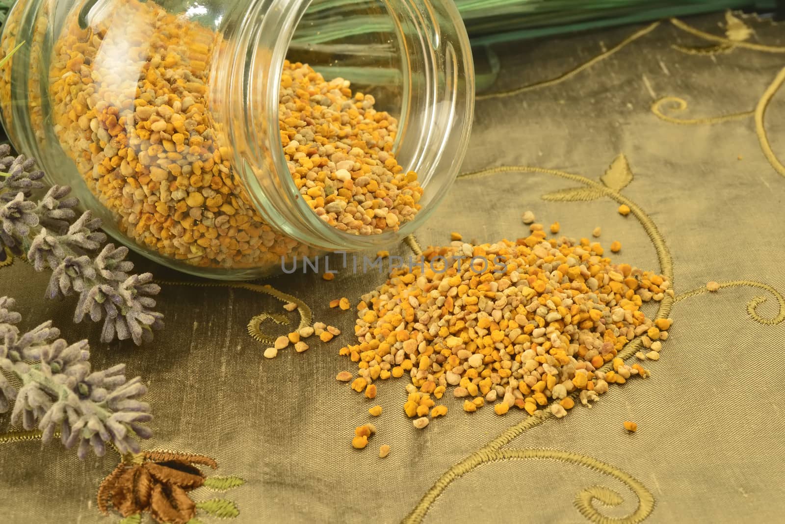 Bee pollen in glass jar and flowers  by Carche
