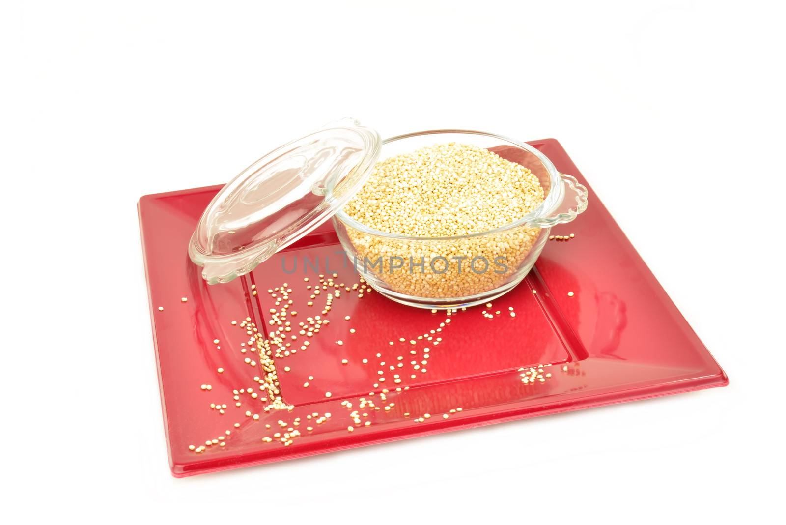 quinoa in glass bowl on a red plate isolated on white background