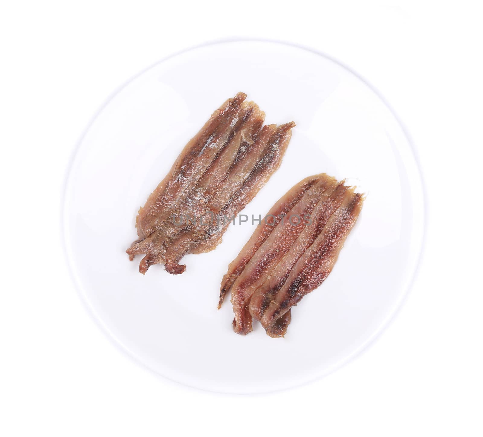 Marinated anchovies on a white plate. Isolated.
