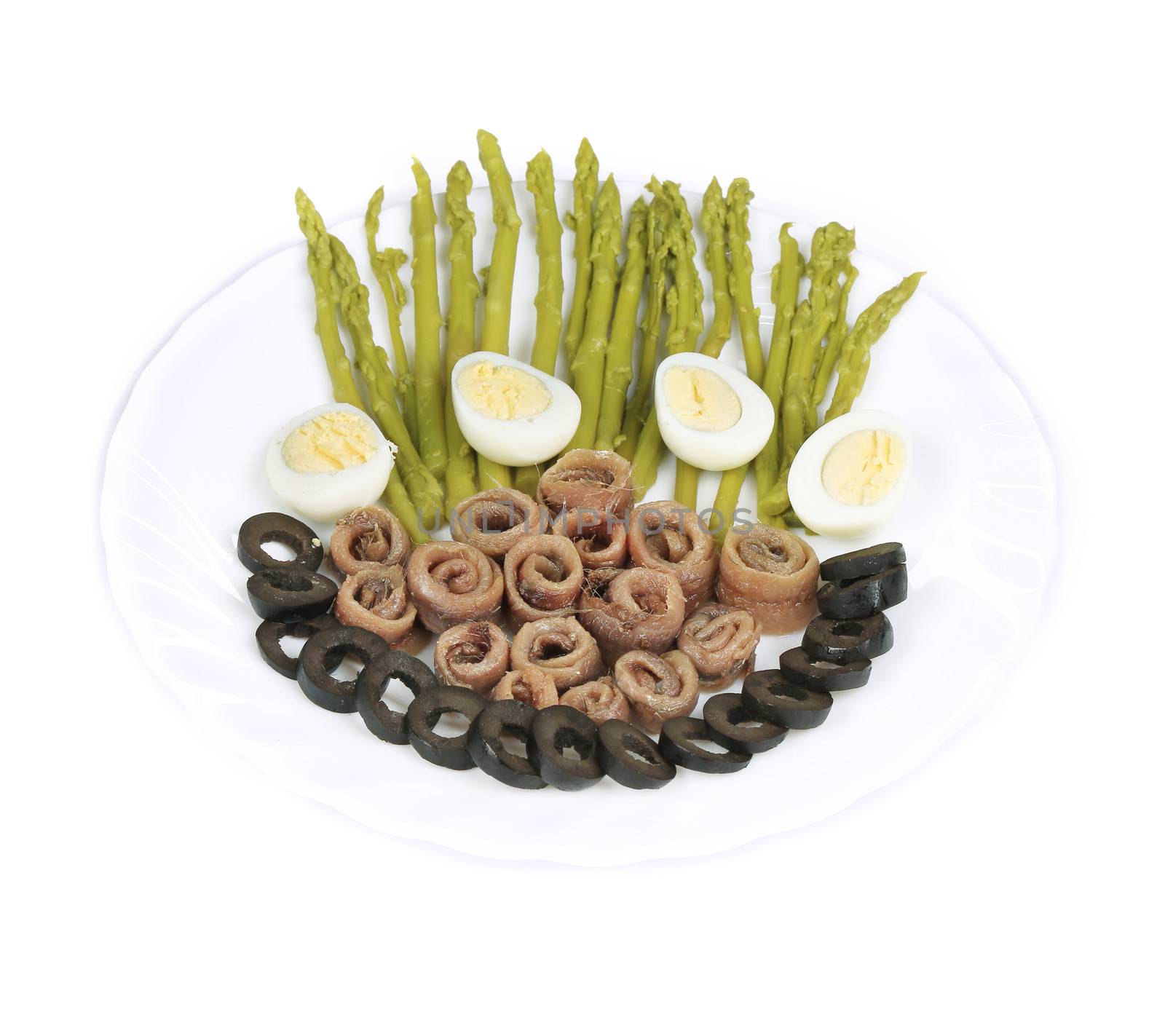 Salad with anchovies and asparagus. On a white background.