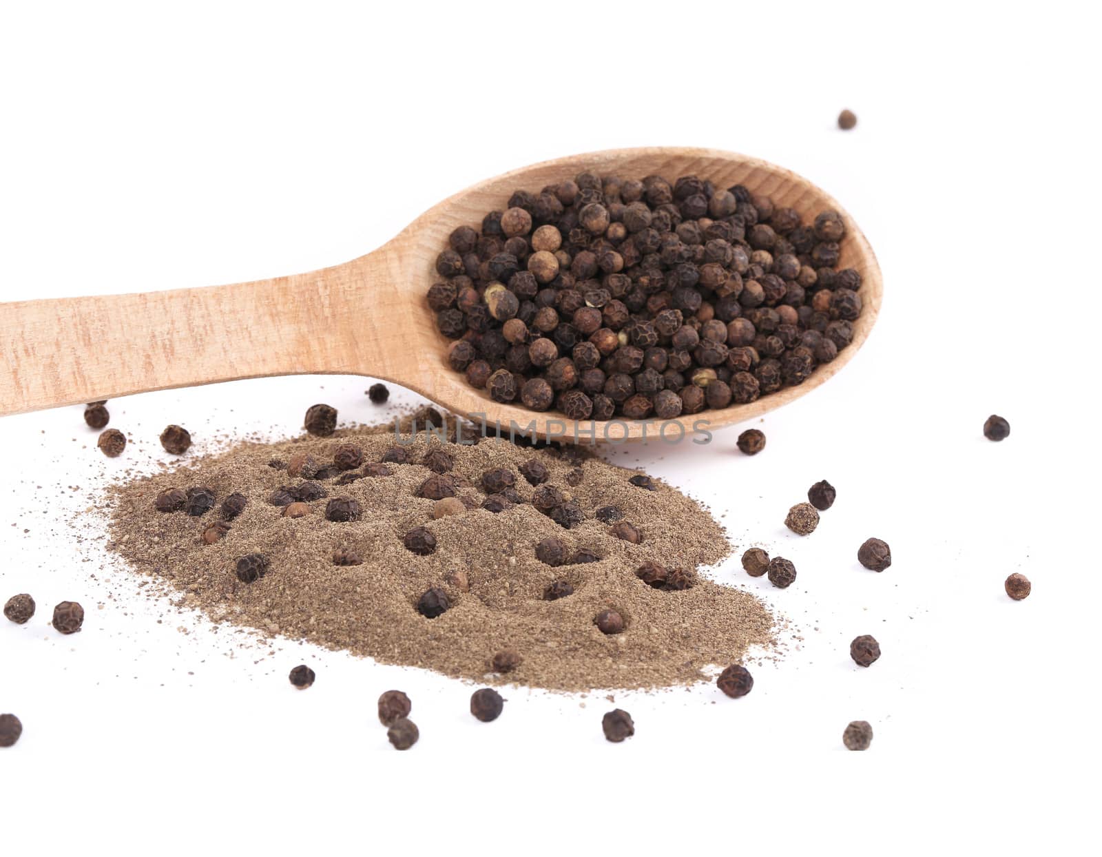 black peppercorns and milled in wooden spoon.Isolated on a white background