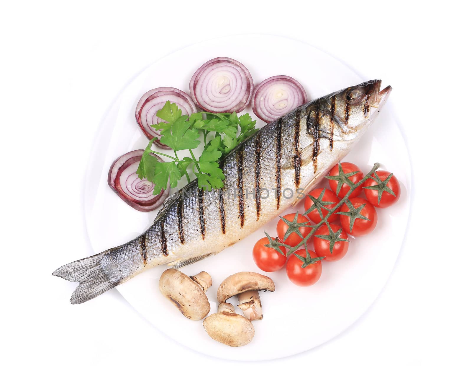 Grilled fish with vegetables. Isolated on a white plate.