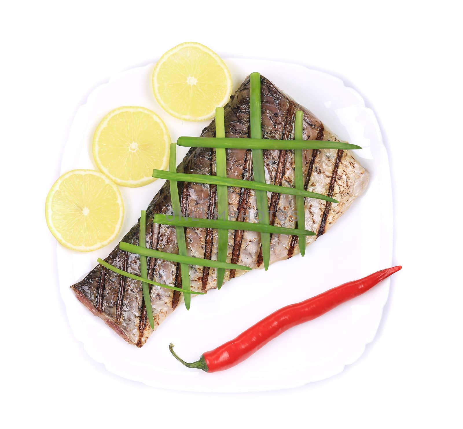 Grilled carp fillet on plate with onion and lemon. Isolated on a white background.