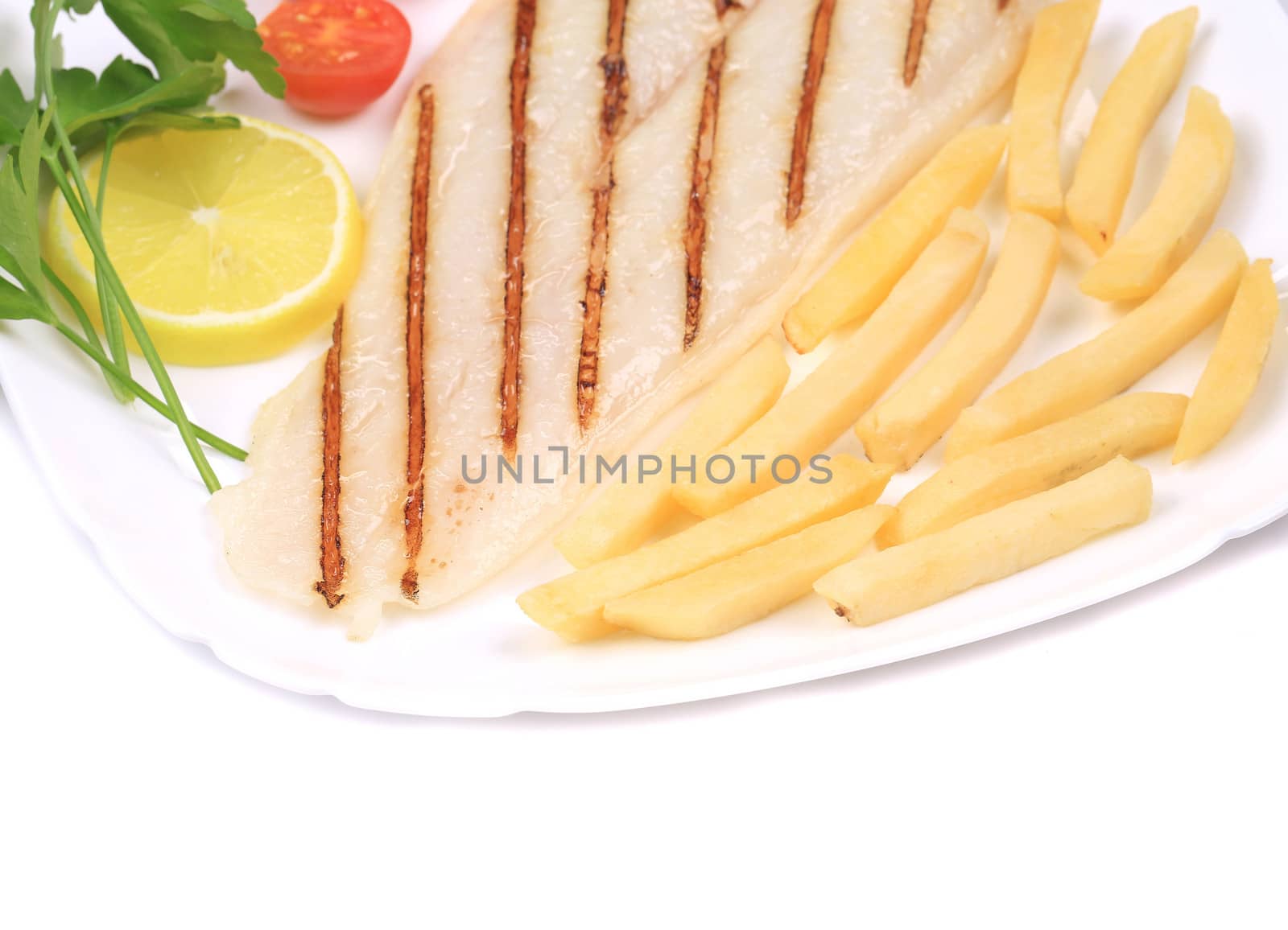 Fried fish fillet with fries and vegetables. Isolated on a white late.
