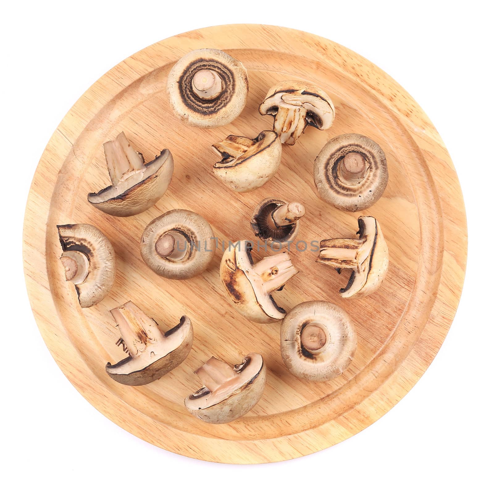 Mushrooms on wooden platter. Isolated on white background.