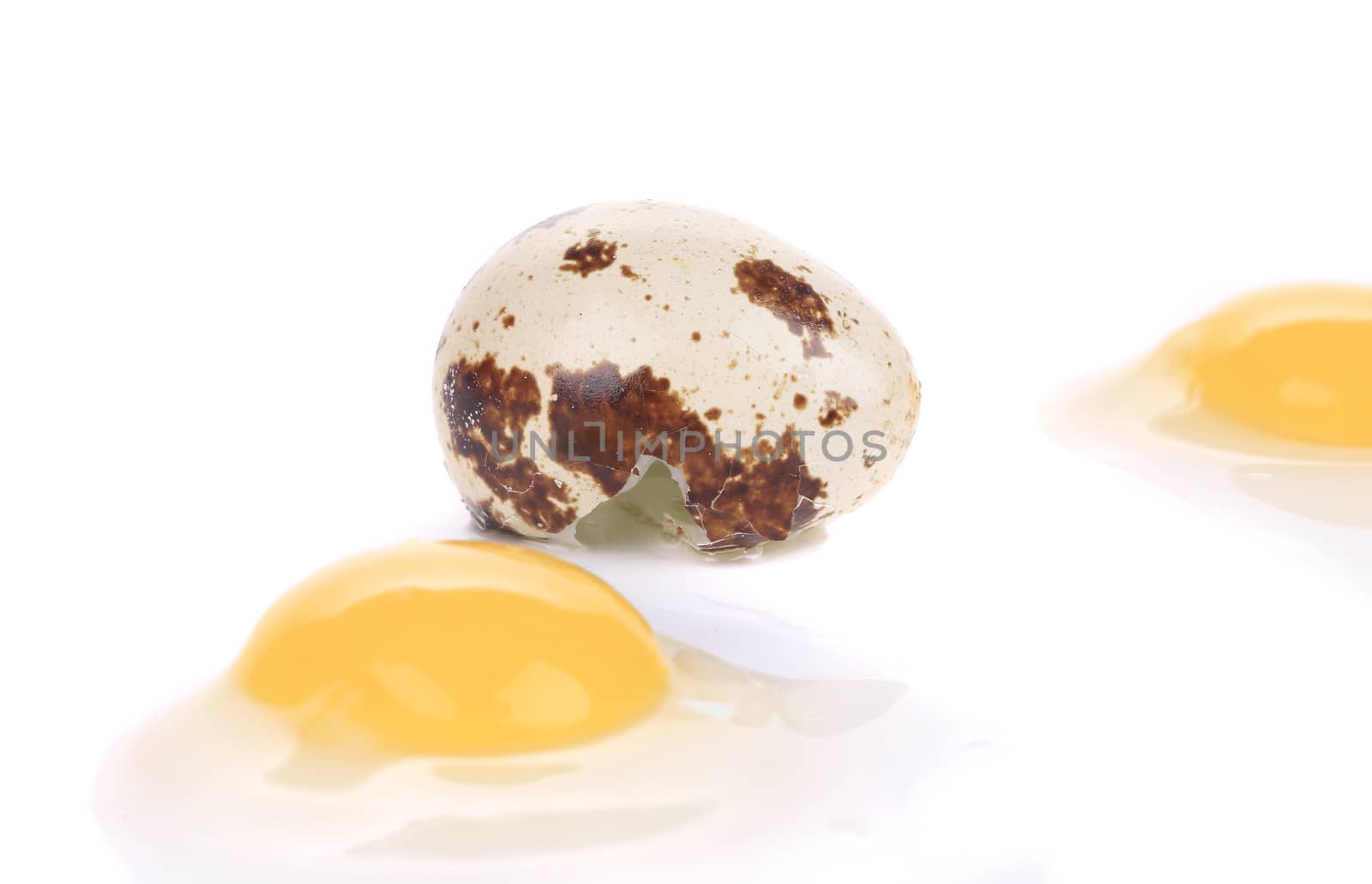 Close up of raw broken quail eggs. Isolated on a white background.
