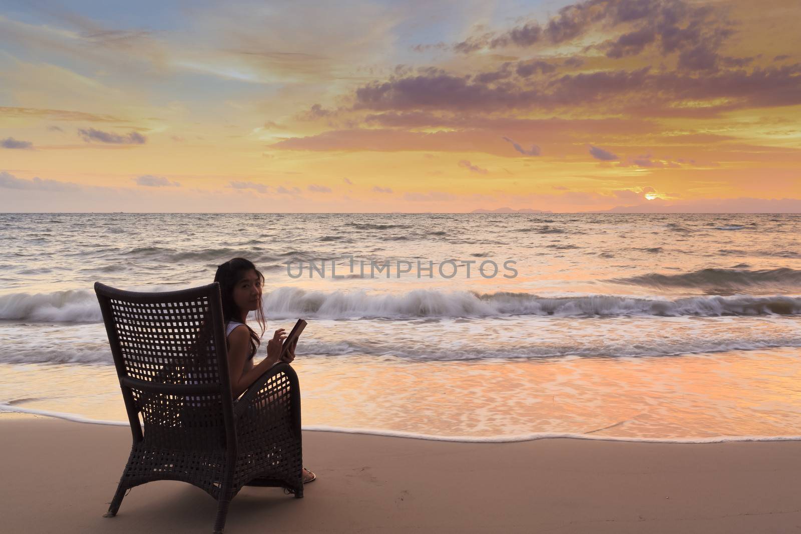 Happy Woman Holding Digital Tablet and Smiling at sunset by FrameAngel