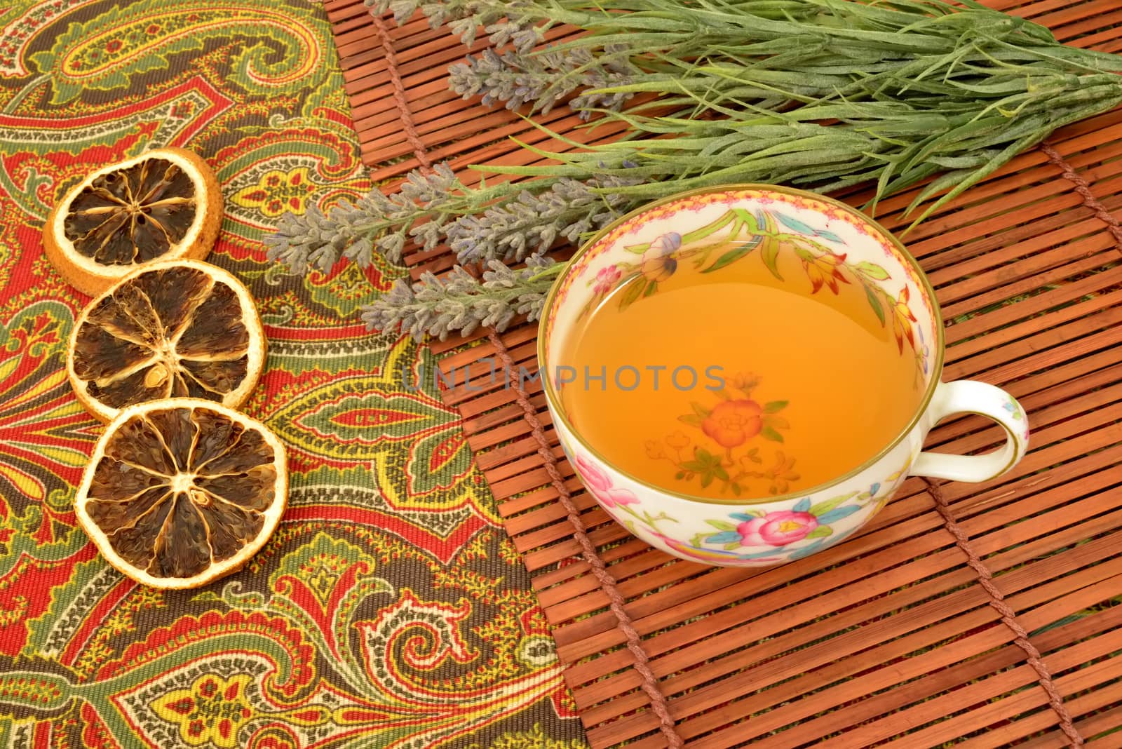 cup of herbal tea and fruit in old cup on  tablecloth