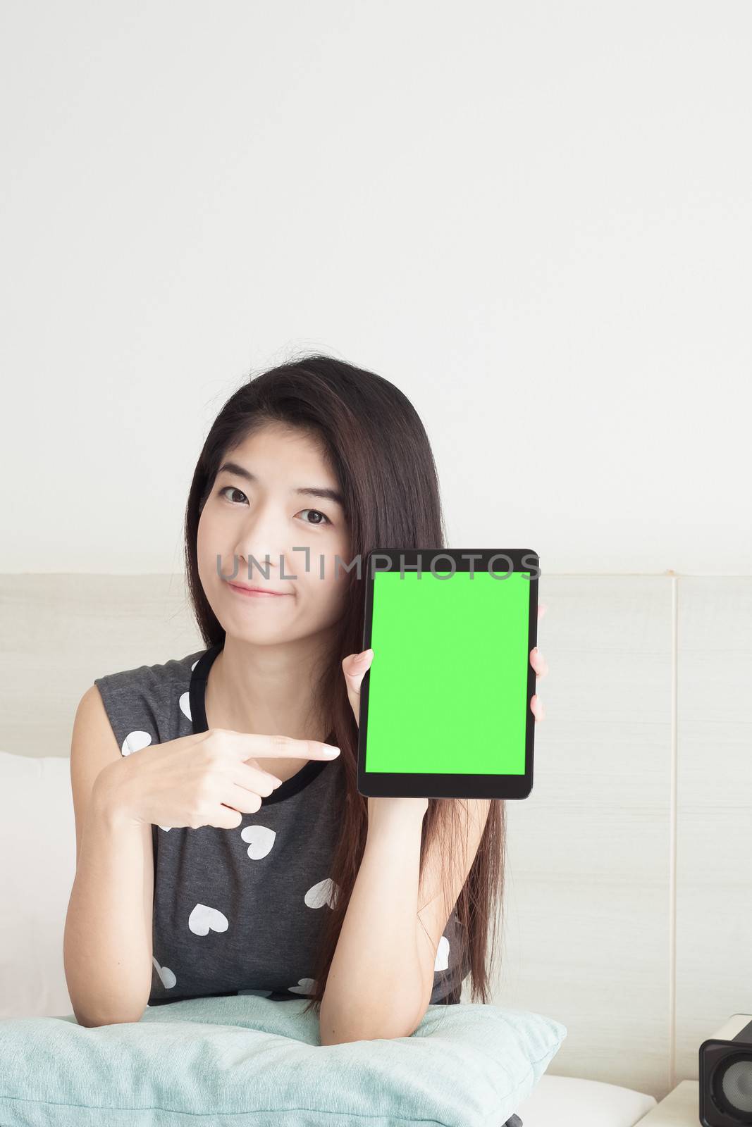 Young Asian woman show or display tablet with green screen