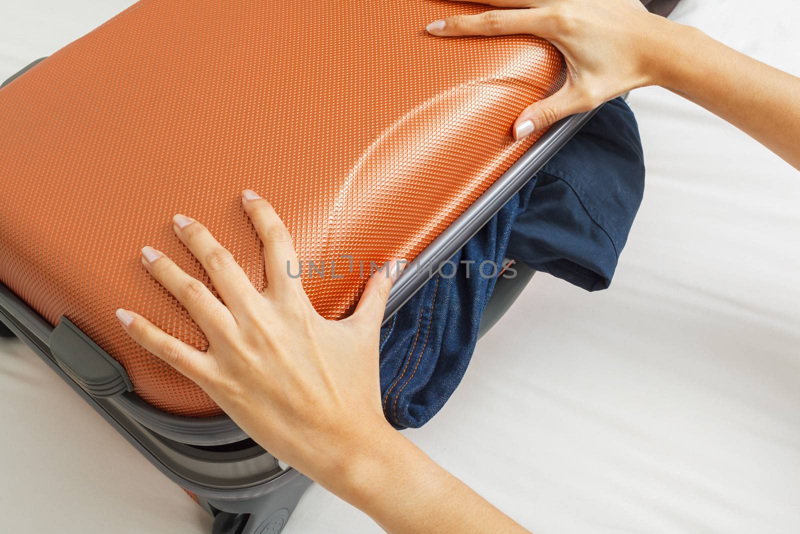 open suitcase with clothes on bed
