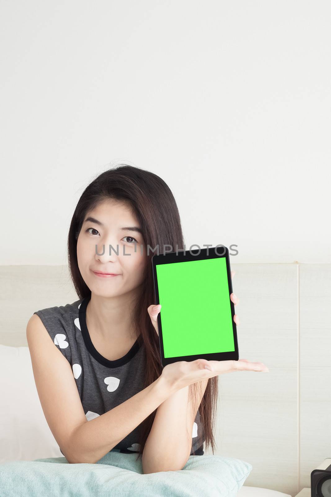 Young Asian woman show or display tablet with green screen