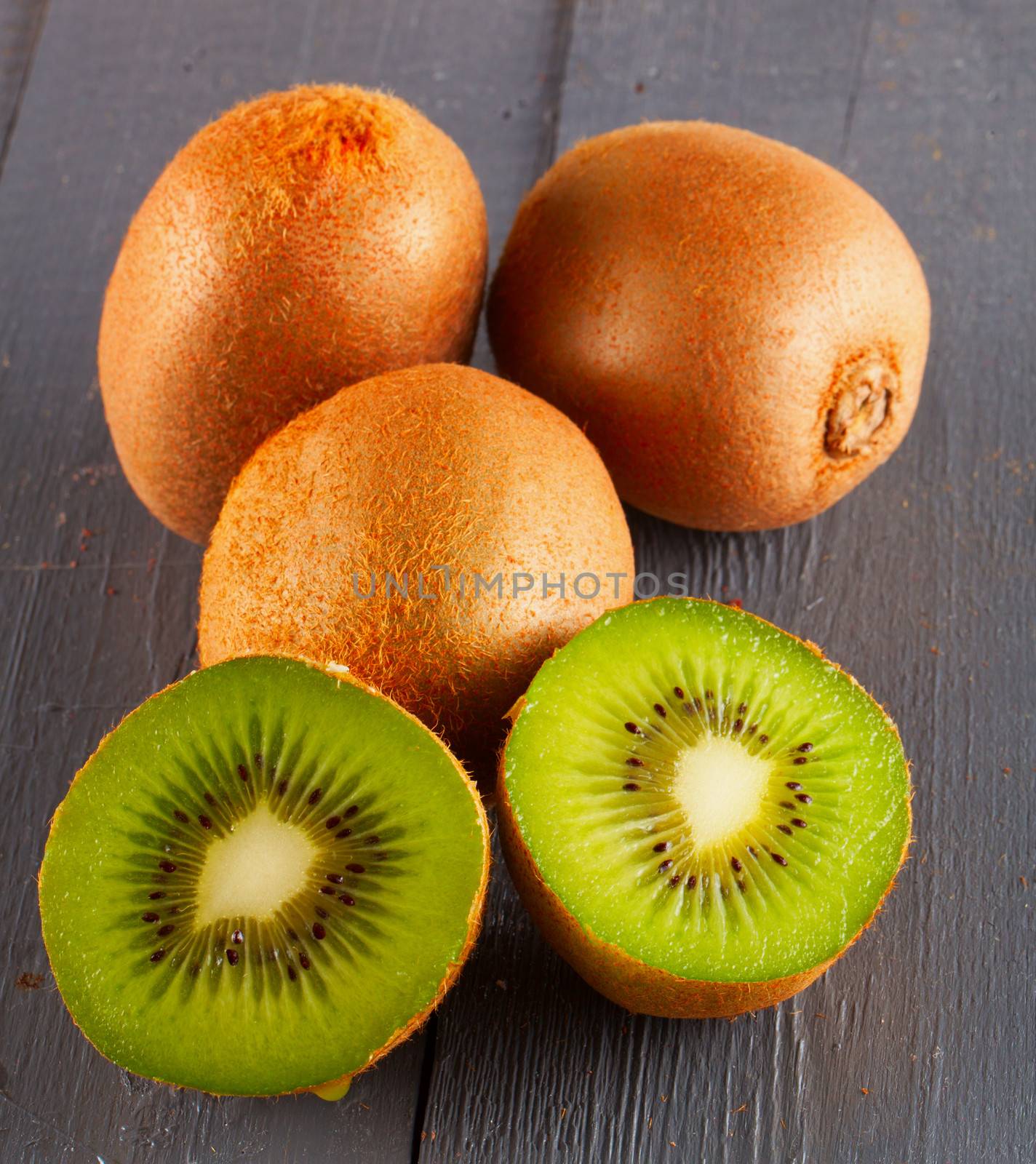 A bunch of kiwis over grey wooden background