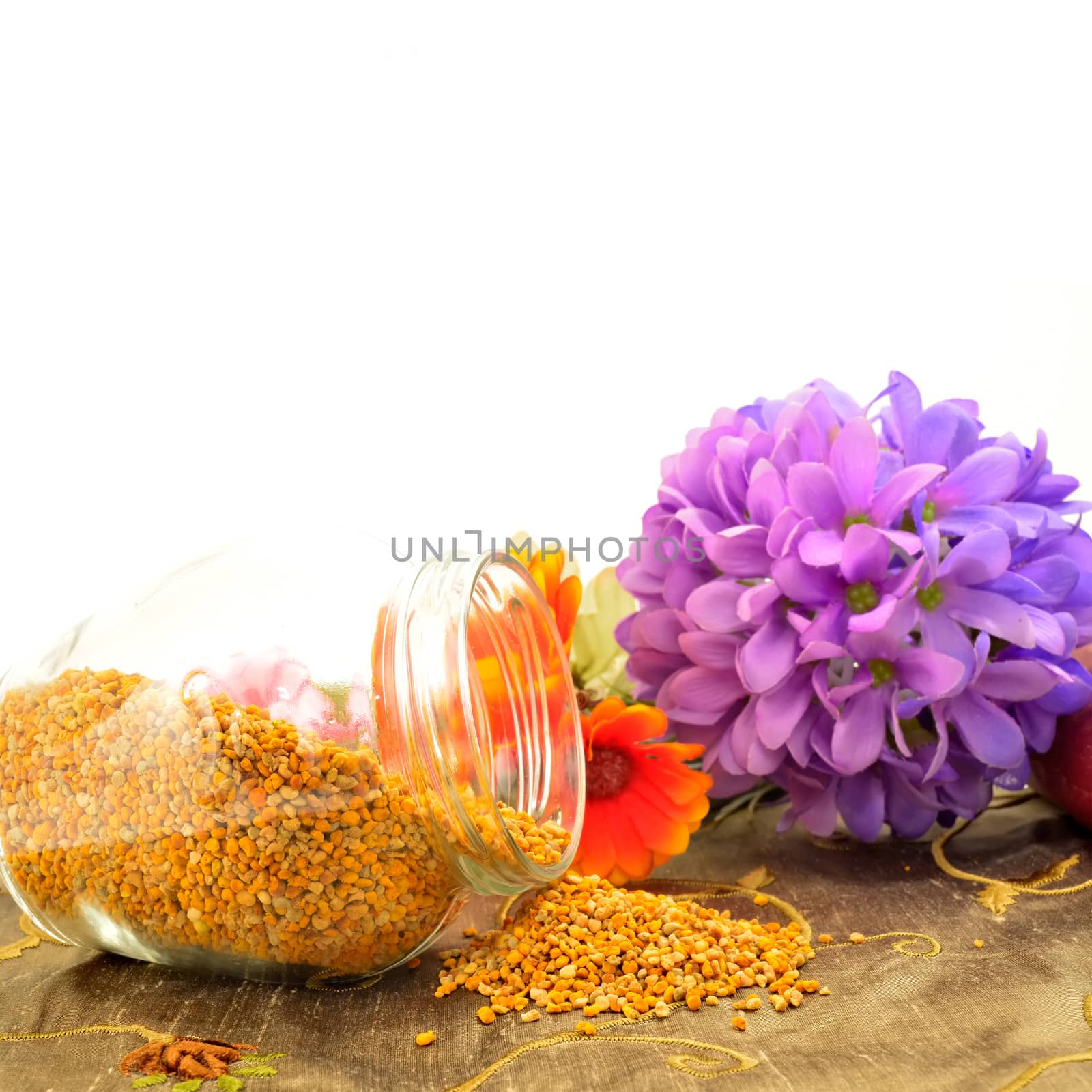 Bee pollen in glass jar and flowers copy space for text