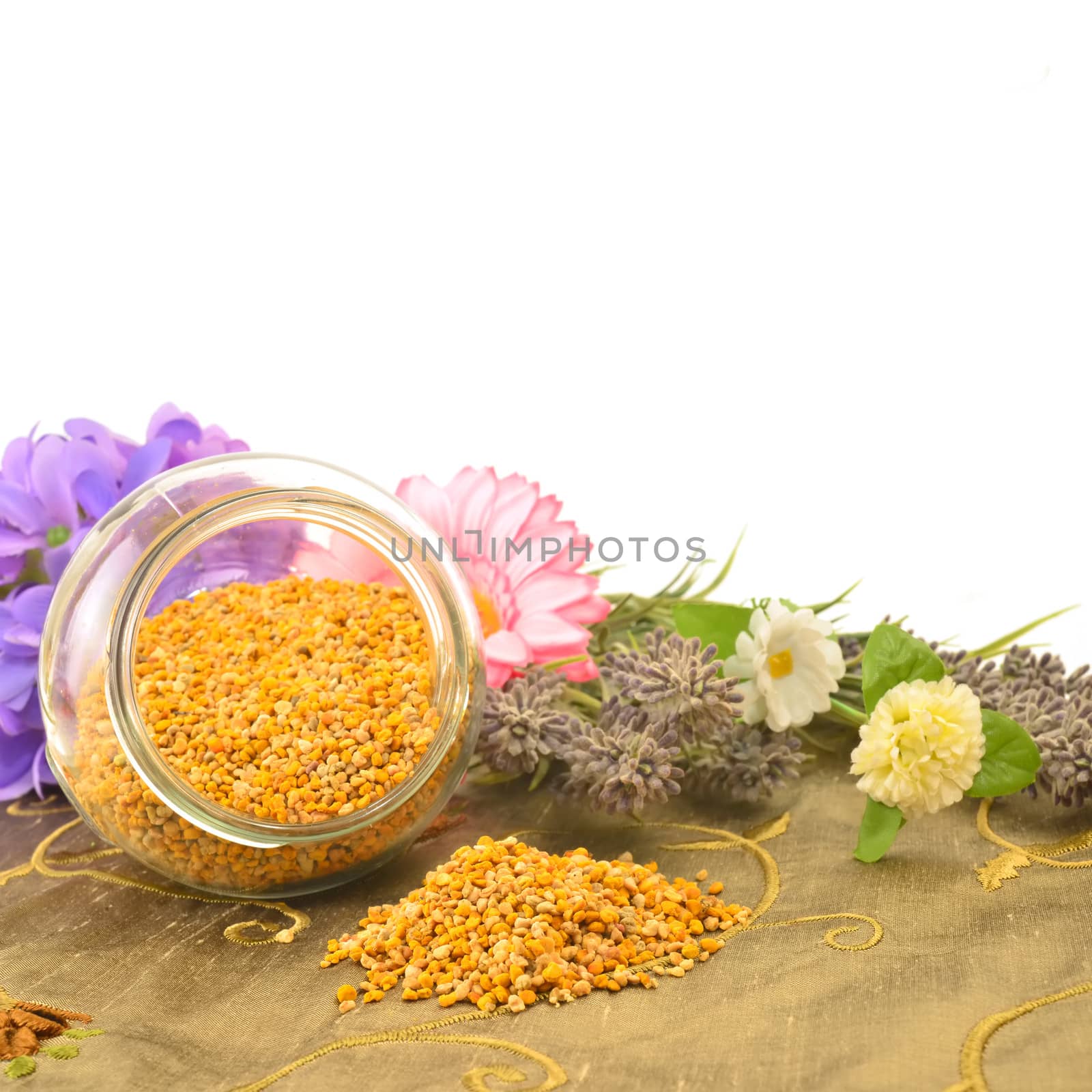 Bee pollen in glass jar and flowers with copy space for text