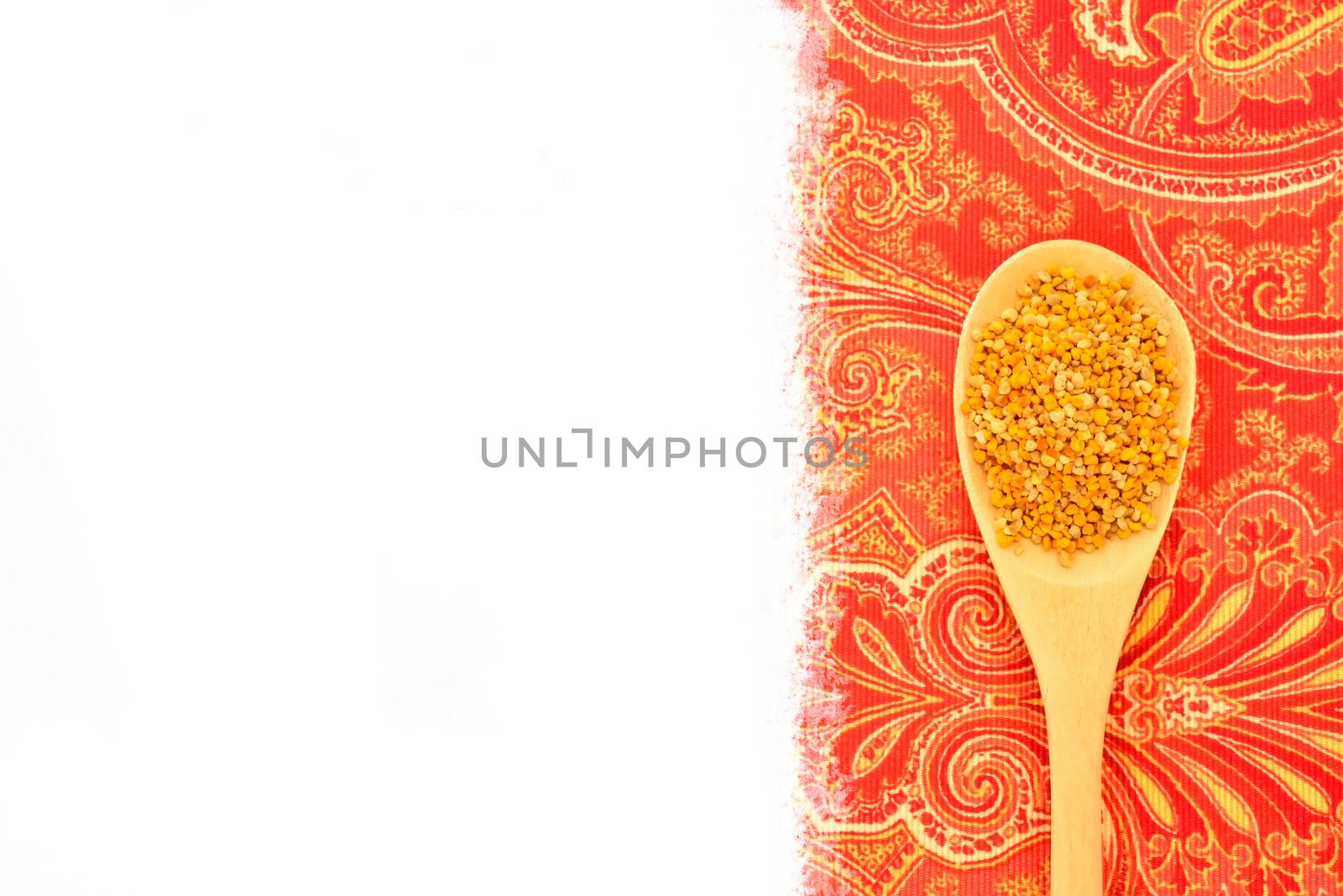 Bee pollen in wooden spoon, rustic fabric background with blank space for text