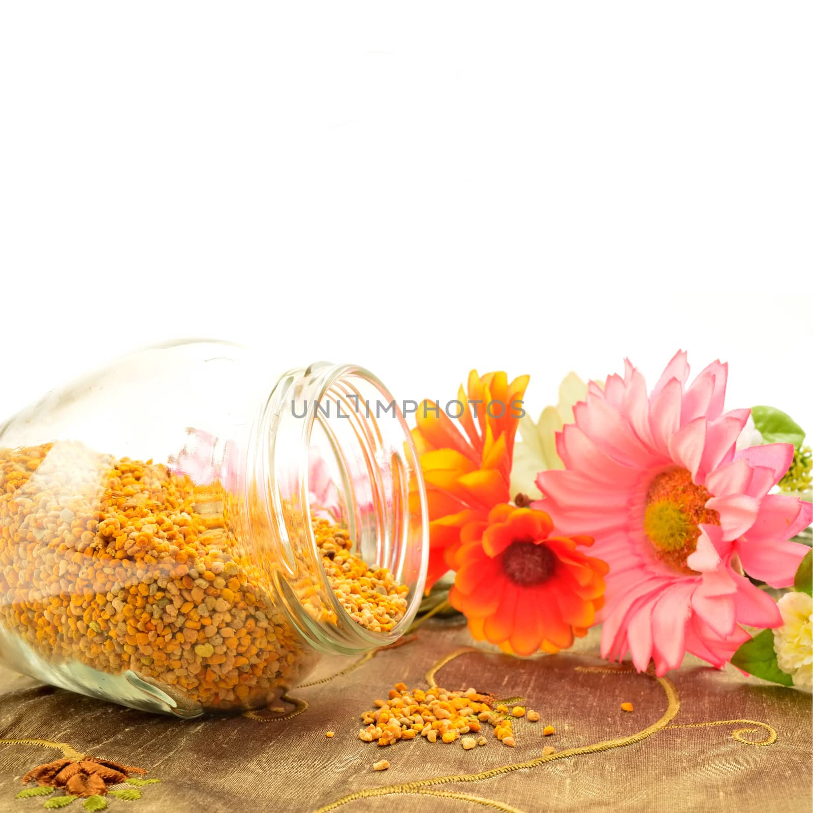 Bee pollen in glass jar and flowers with copy  space for text