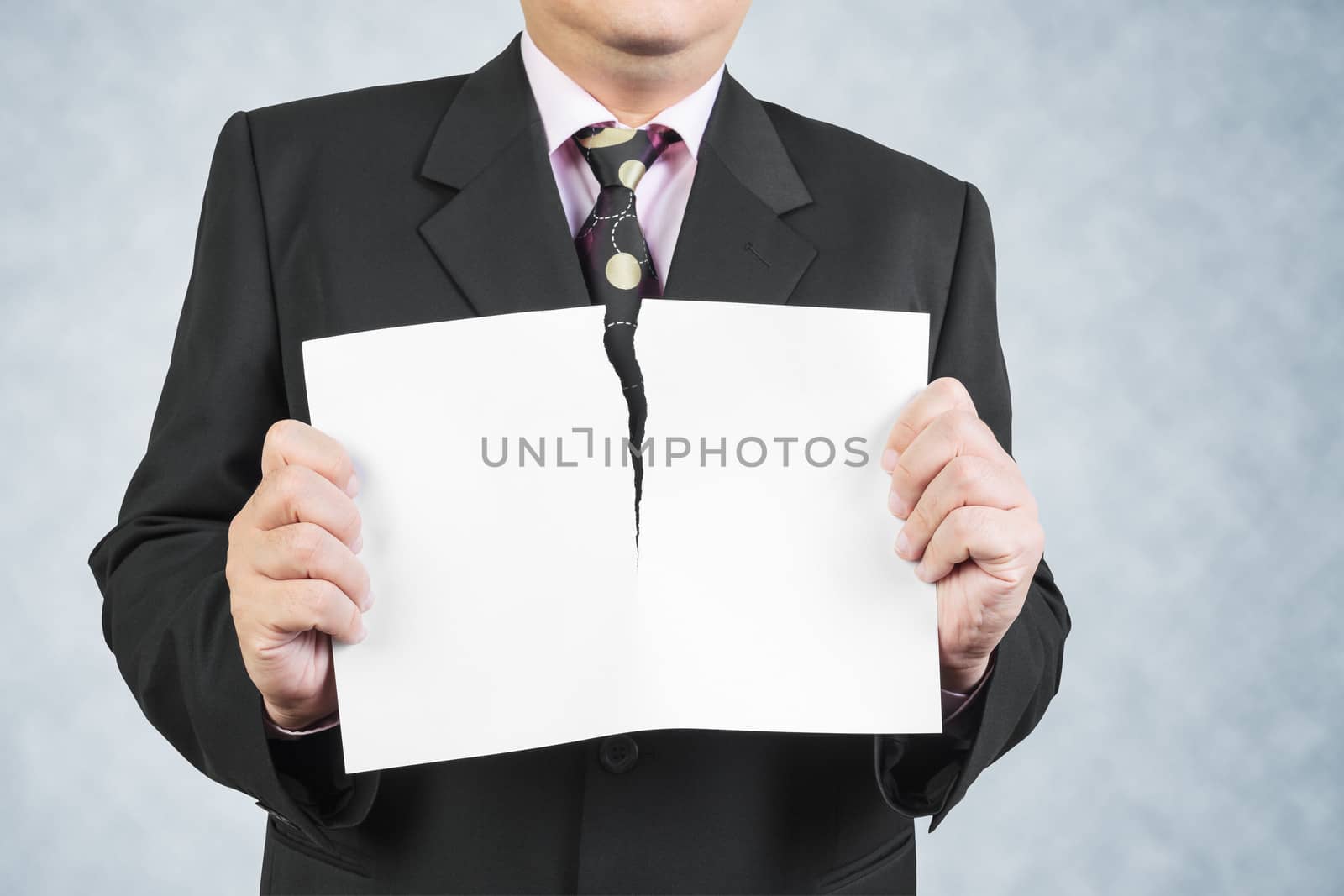 Businessman tearing sheet white paper on white background