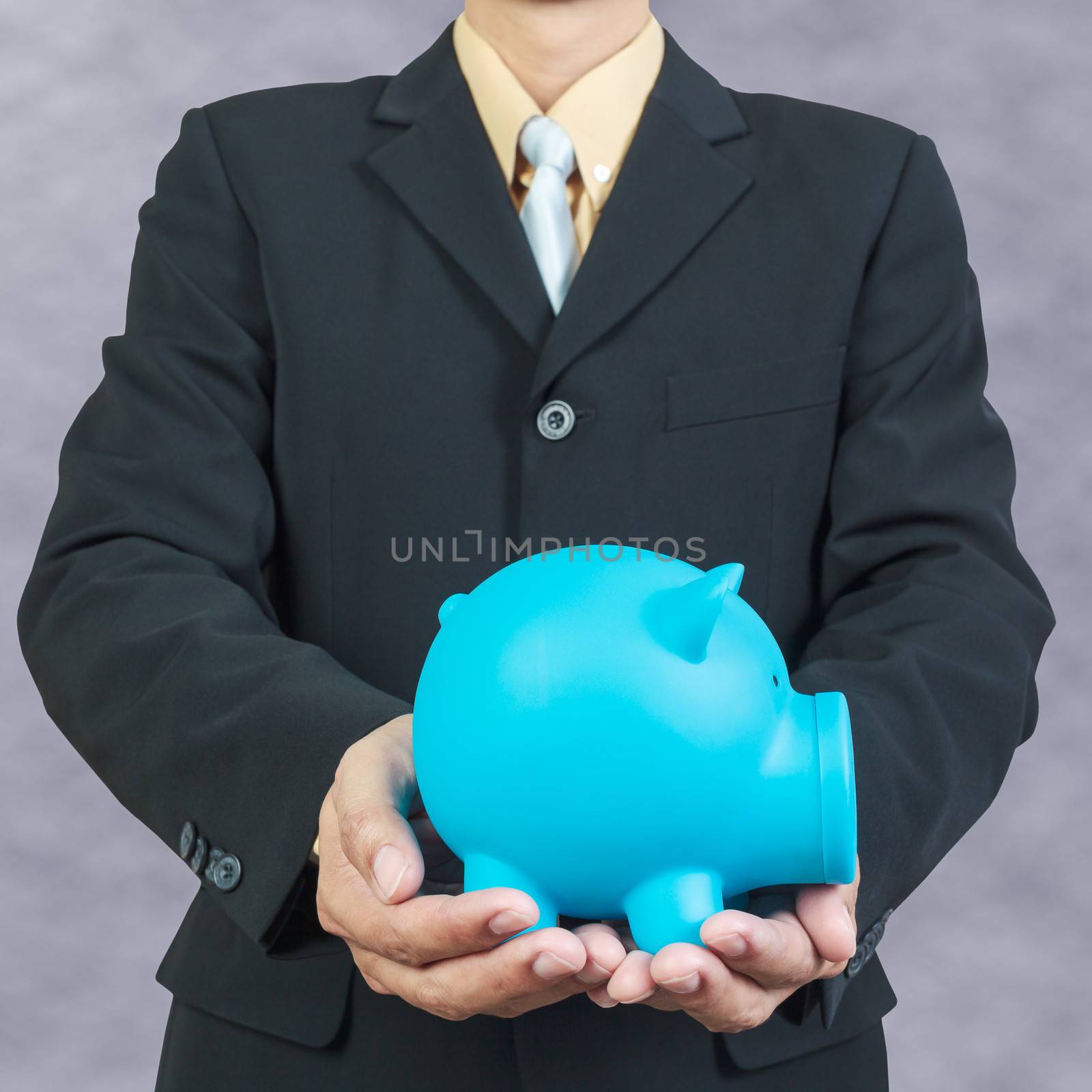 Businessman hand holding piggy bank on white background by FrameAngel
