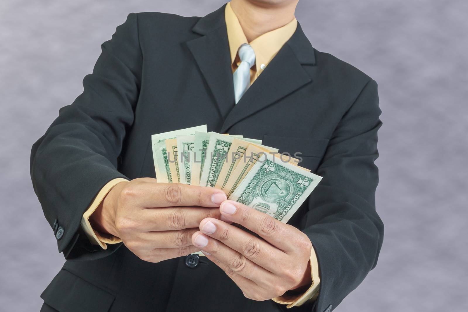 Businessman holding Money Cash Dollars in hands, finance concept