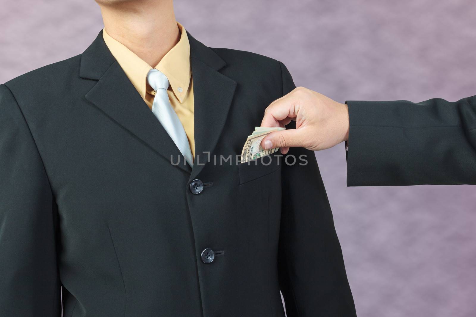 businessman hand put money to pocket, finance corruption concept