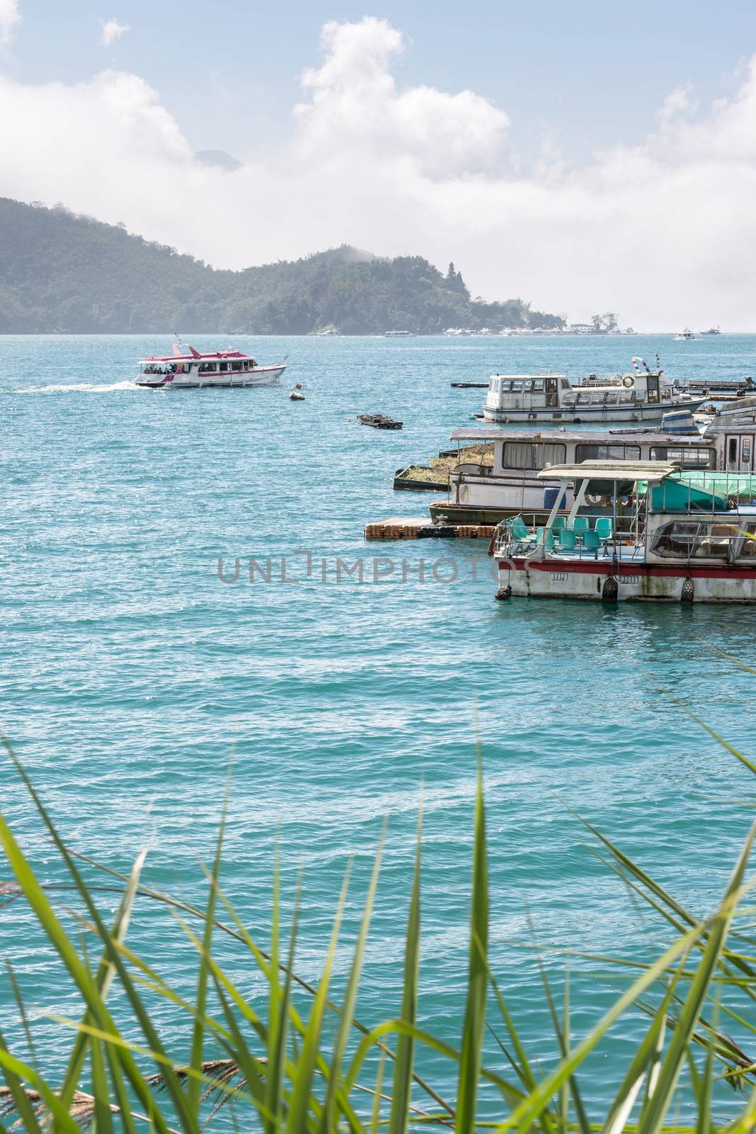 Landscape of famous attraction, Sun Moon Lake at Taiwan, with boats on dock at sunny day.