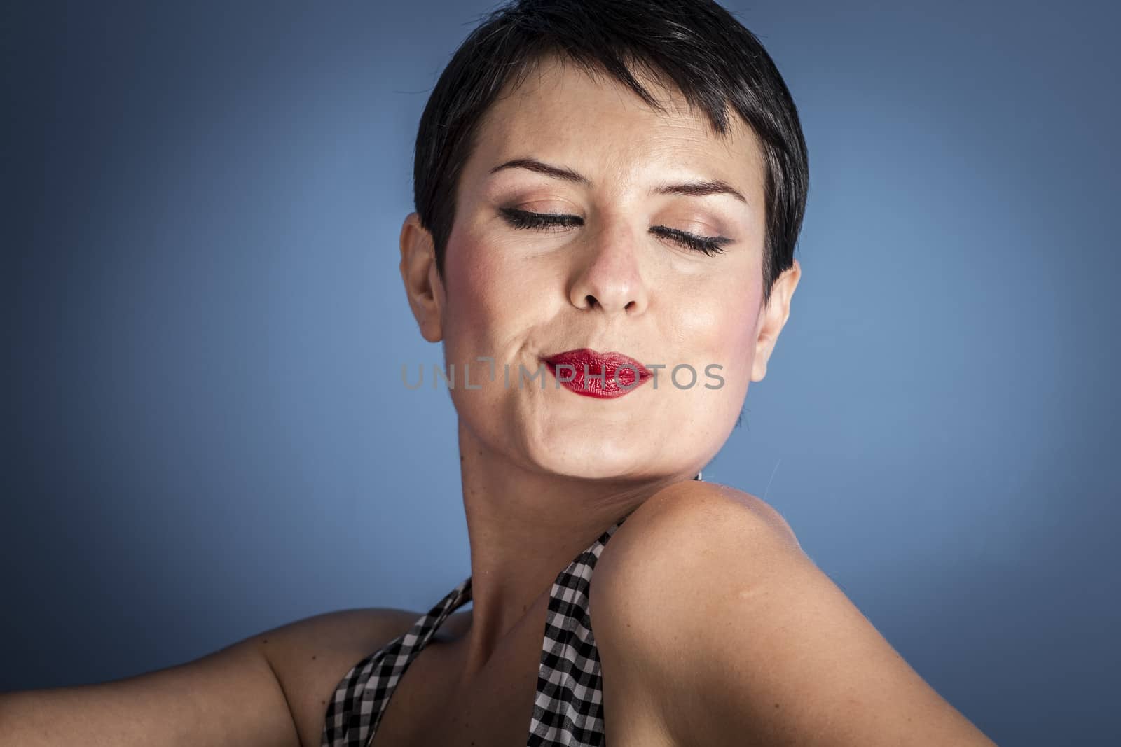 happy young woman with lollypop in her mouth on blue background