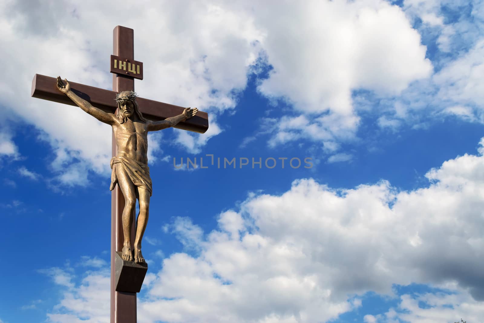 Statue of the crucifixion on a background of the cloudy sky. Dniprodzerzhyns'k, Ukraine.
