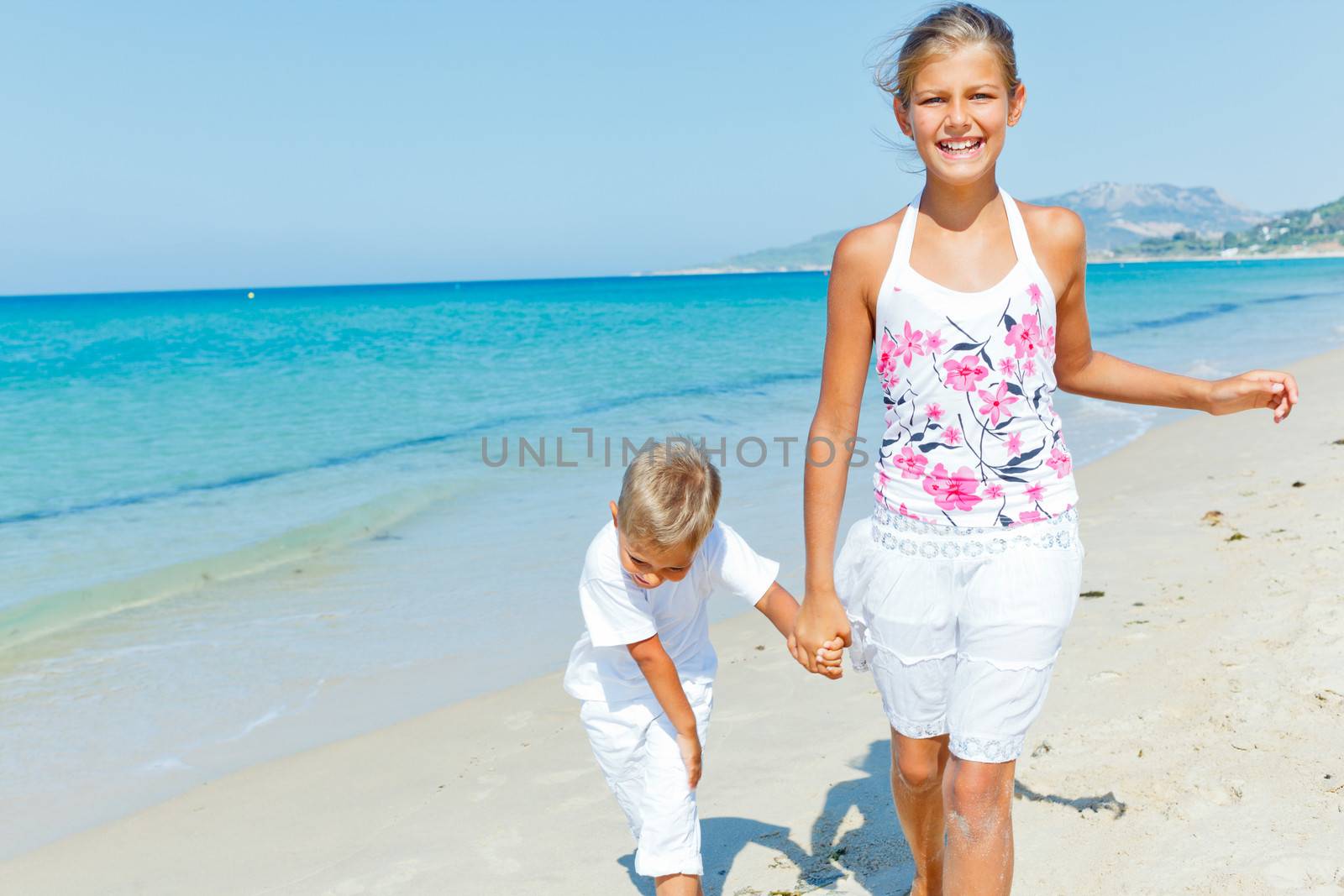 Cute boy and girl on the beach by maxoliki