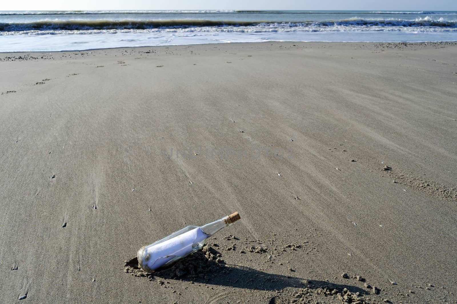 Bottle containing a message of help on a beach