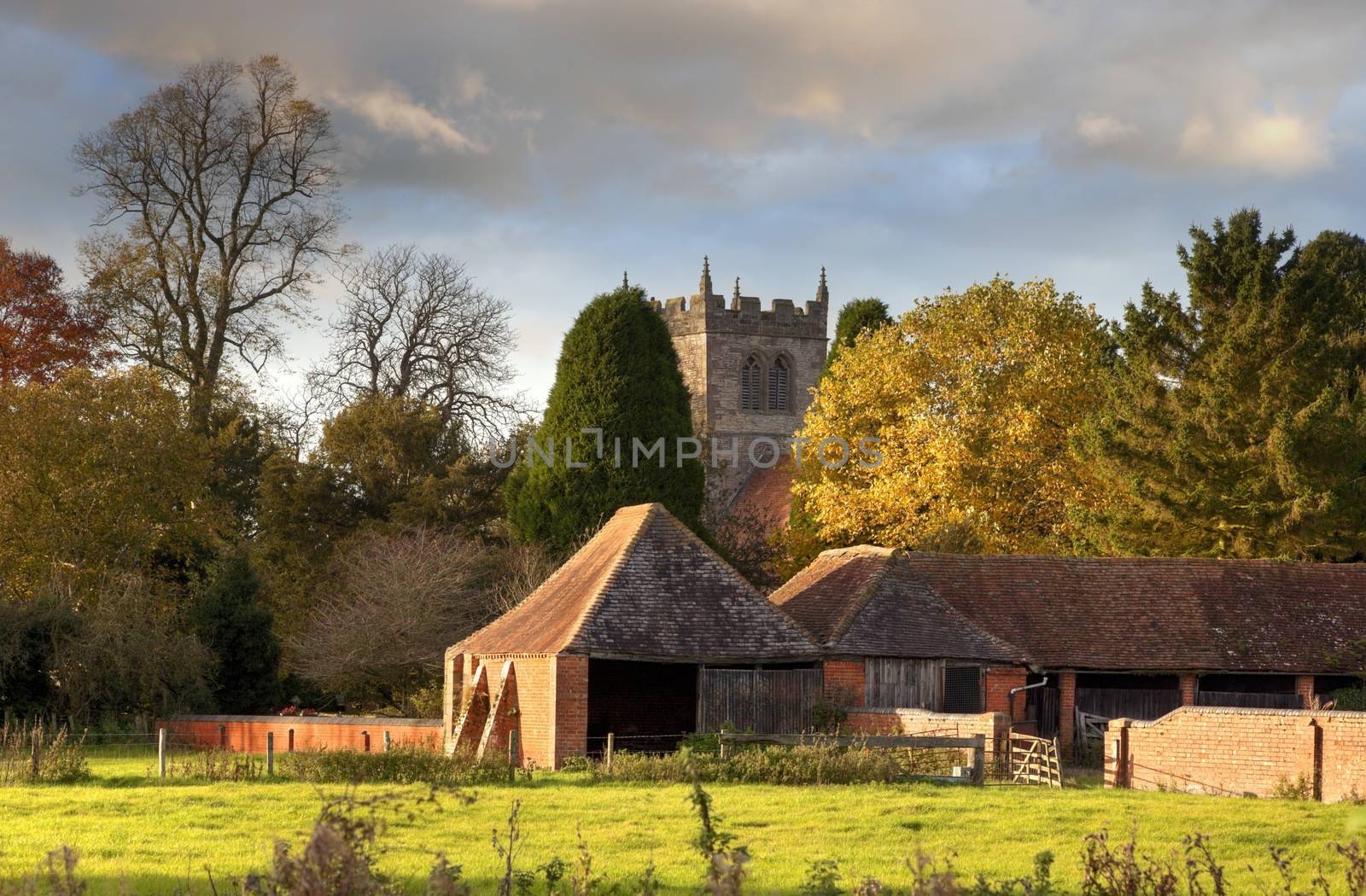 The Warwickshire village of Aston Cantlow, showing old church and barns, England.