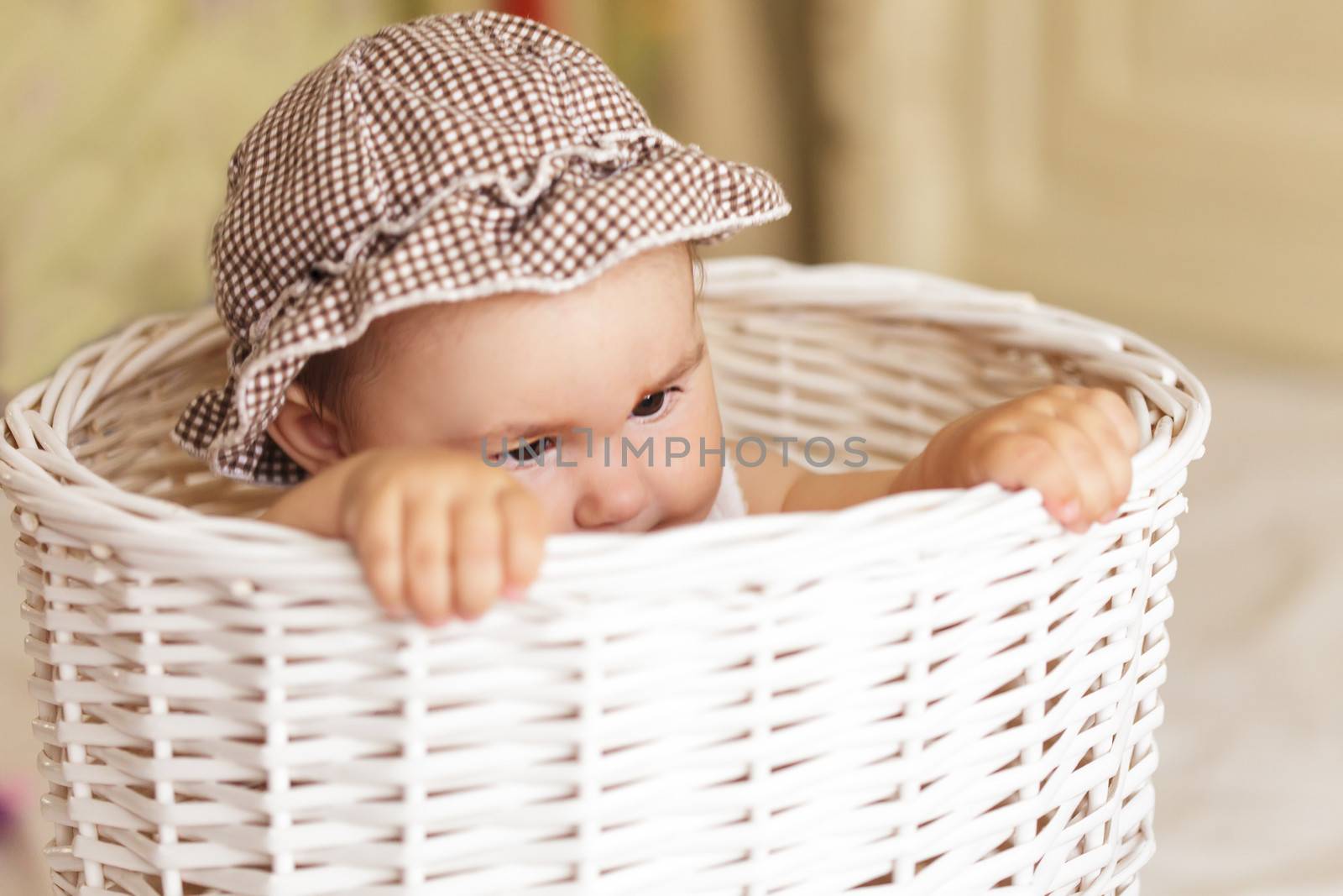 Eight month baby girl play with laundry basket