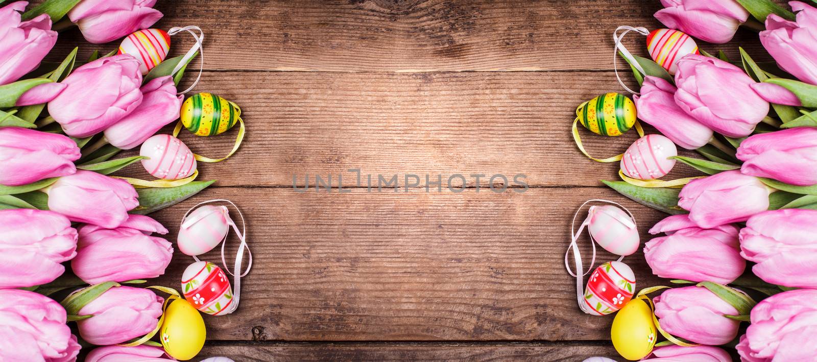 Tulips and eggs border over wooden backdrop. Easter decorations.