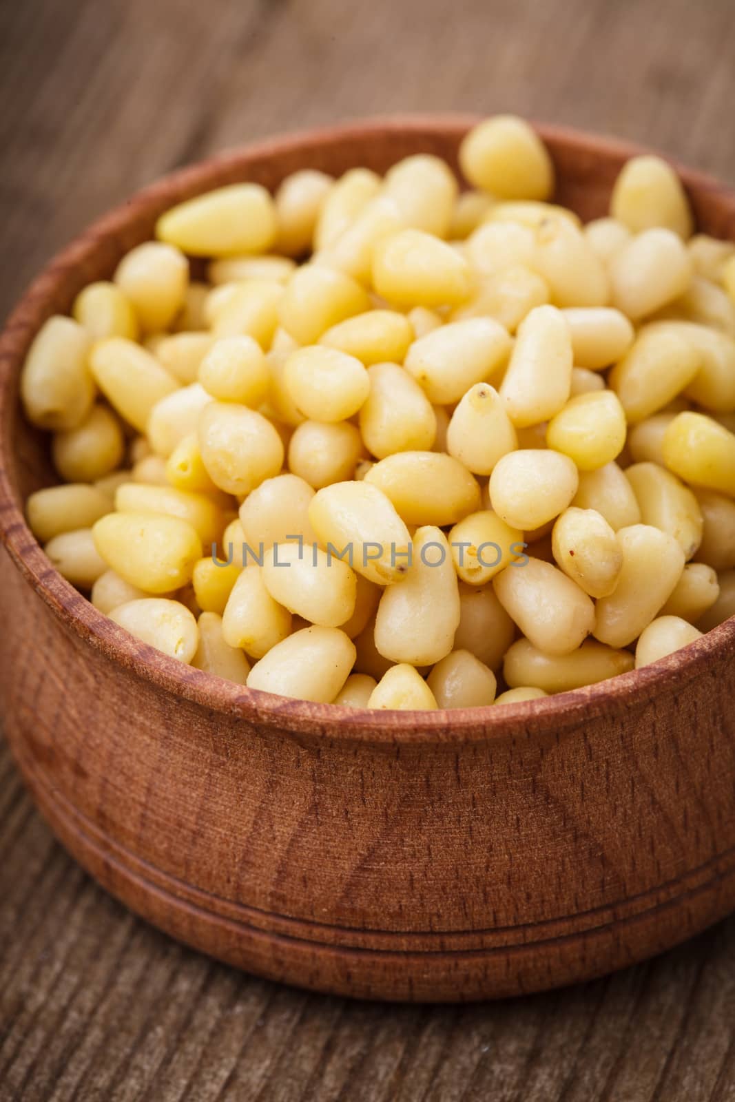 Pine nuts in a wooden bowl close up