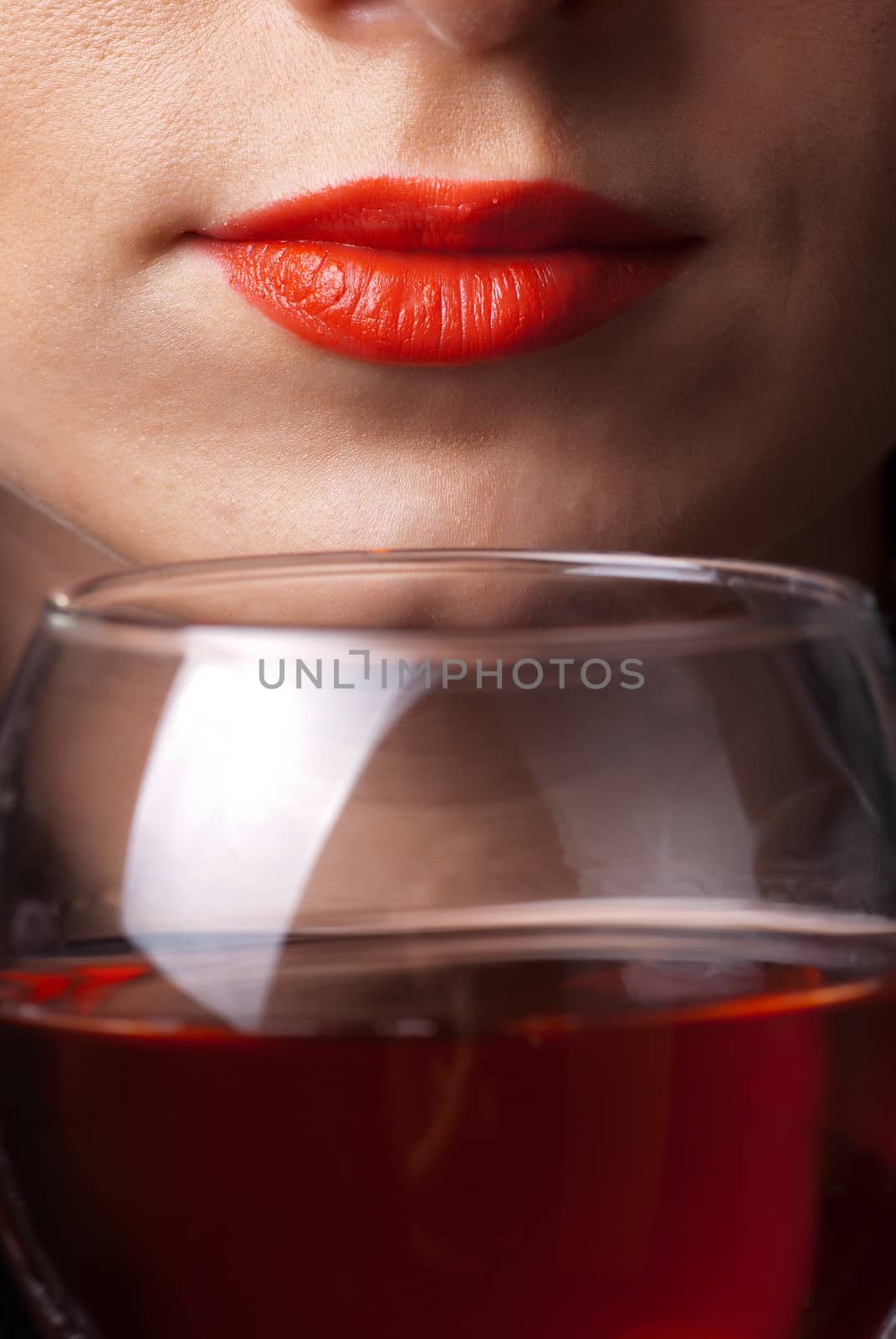 Red lips and glass of wine close up