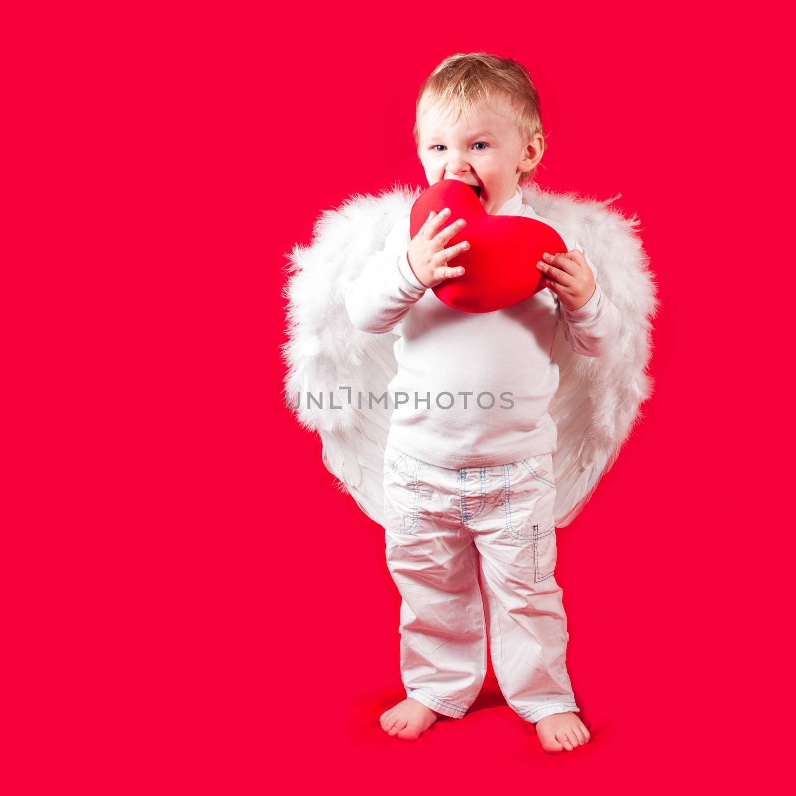 Blonde caucasian boy - Valentine - with yummy heart on red background. Cute Valentine concept