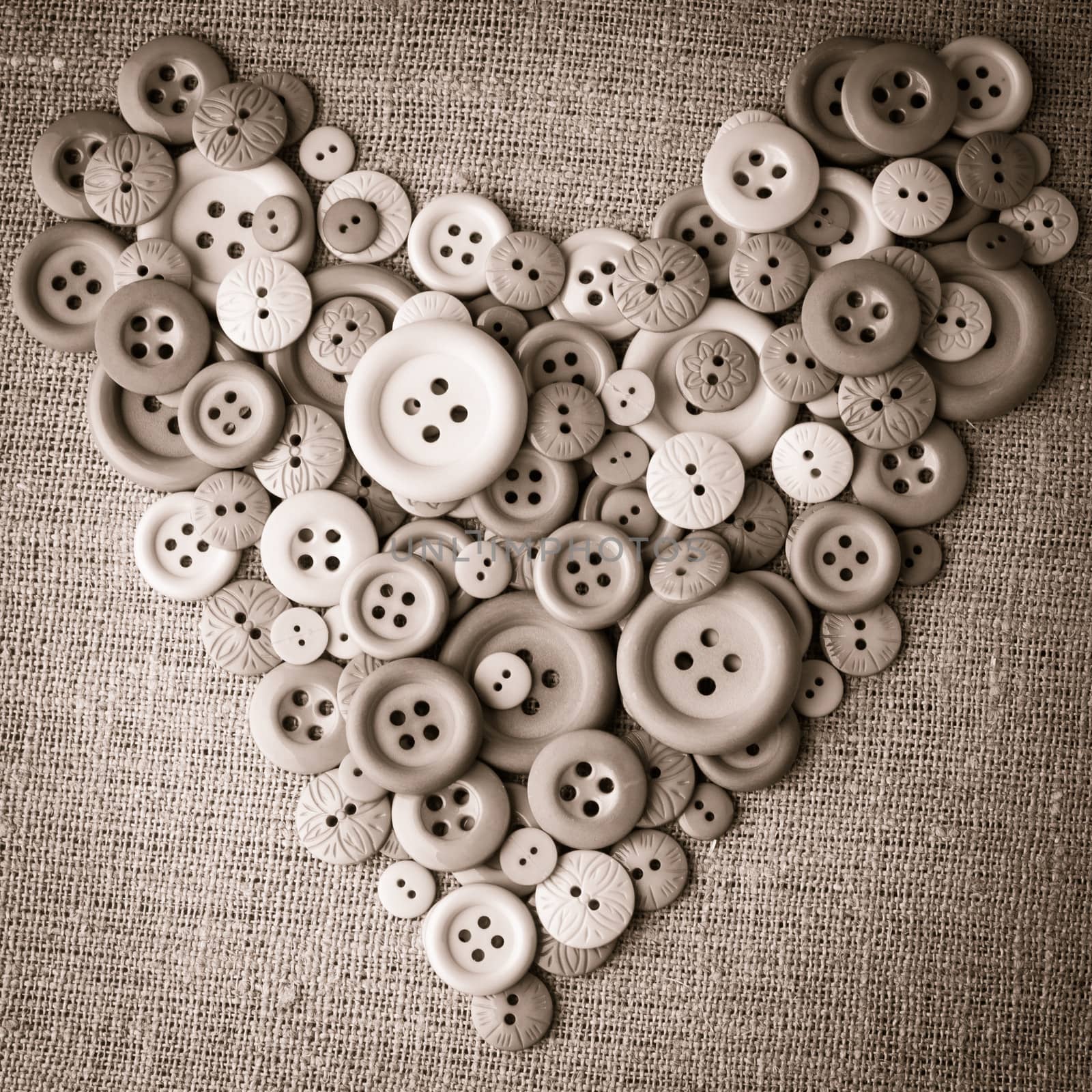 Heart shape from wooden buttons over canvas textile