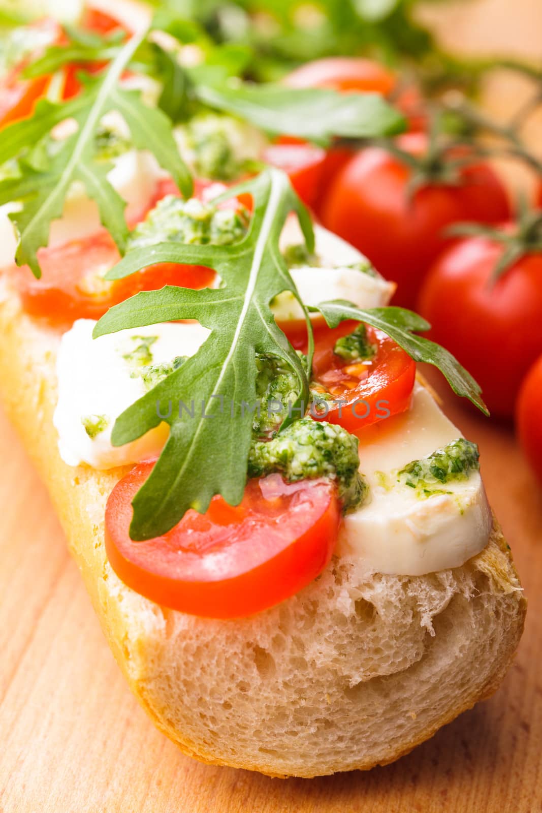 Sandwich with mozzarella, tomato, arugula and pesto